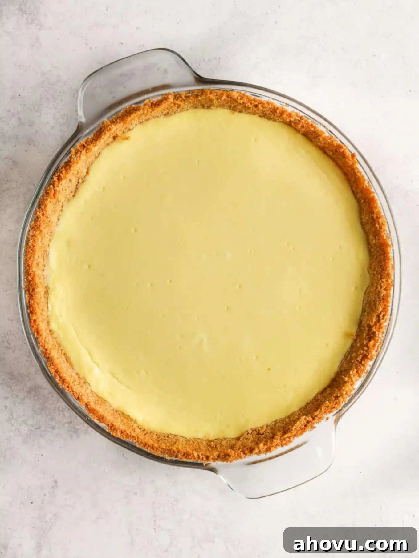 An overhead view of baked cheesecake pie. 