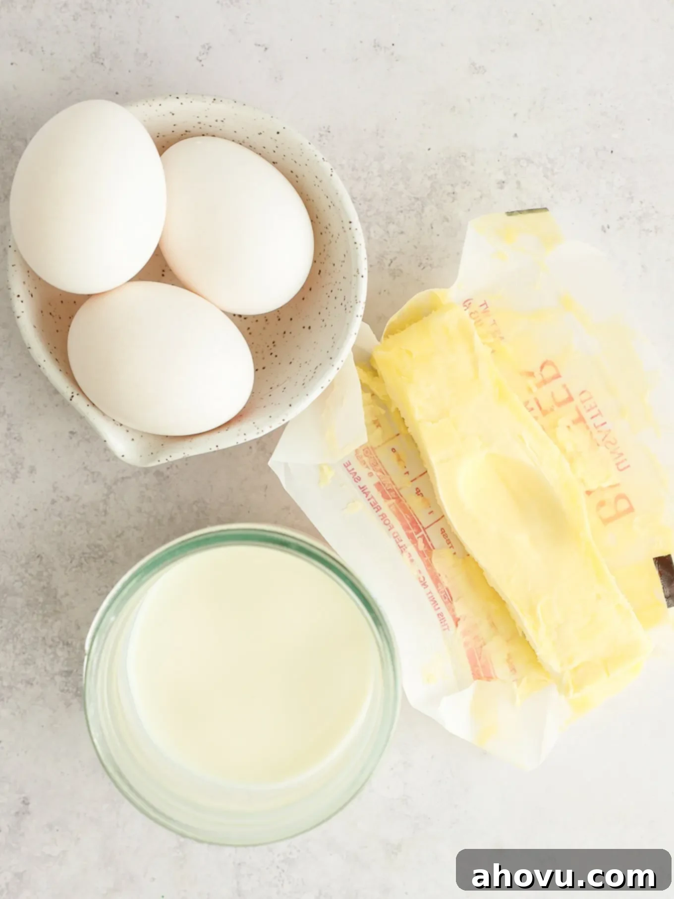 Overhead view of essential baking ingredients like eggs, butter, and buttermilk ready for mixing.