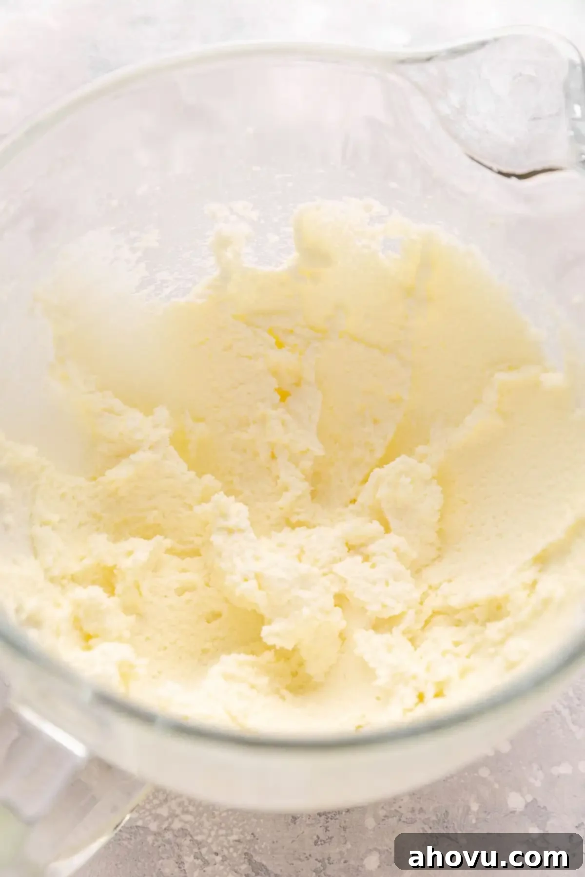 Overhead view of light and fluffy creamed butter and granulated sugar in the bowl of a stand mixer.