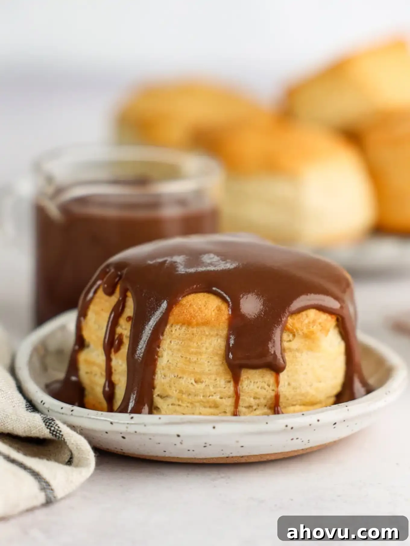 A biscuit topped with chocolate gravy on a plate. 