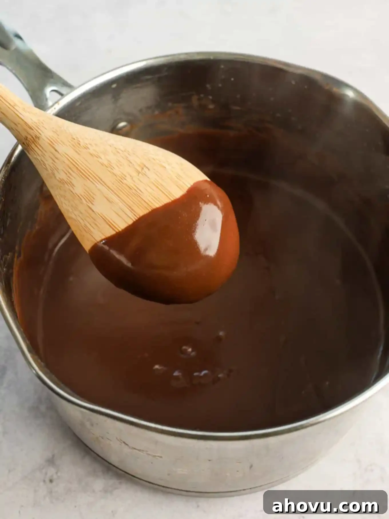Chocolate gravy in a saucepan with a wooden spoon.