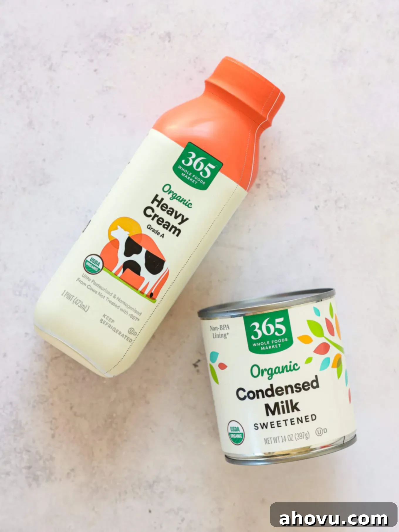 Decadent Chocolate Delight 3 Overhead view of a glass bowl filled with rich heavy cream and a can of sweetened condensed milk, key ingredients for creamy no-churn ice cream.