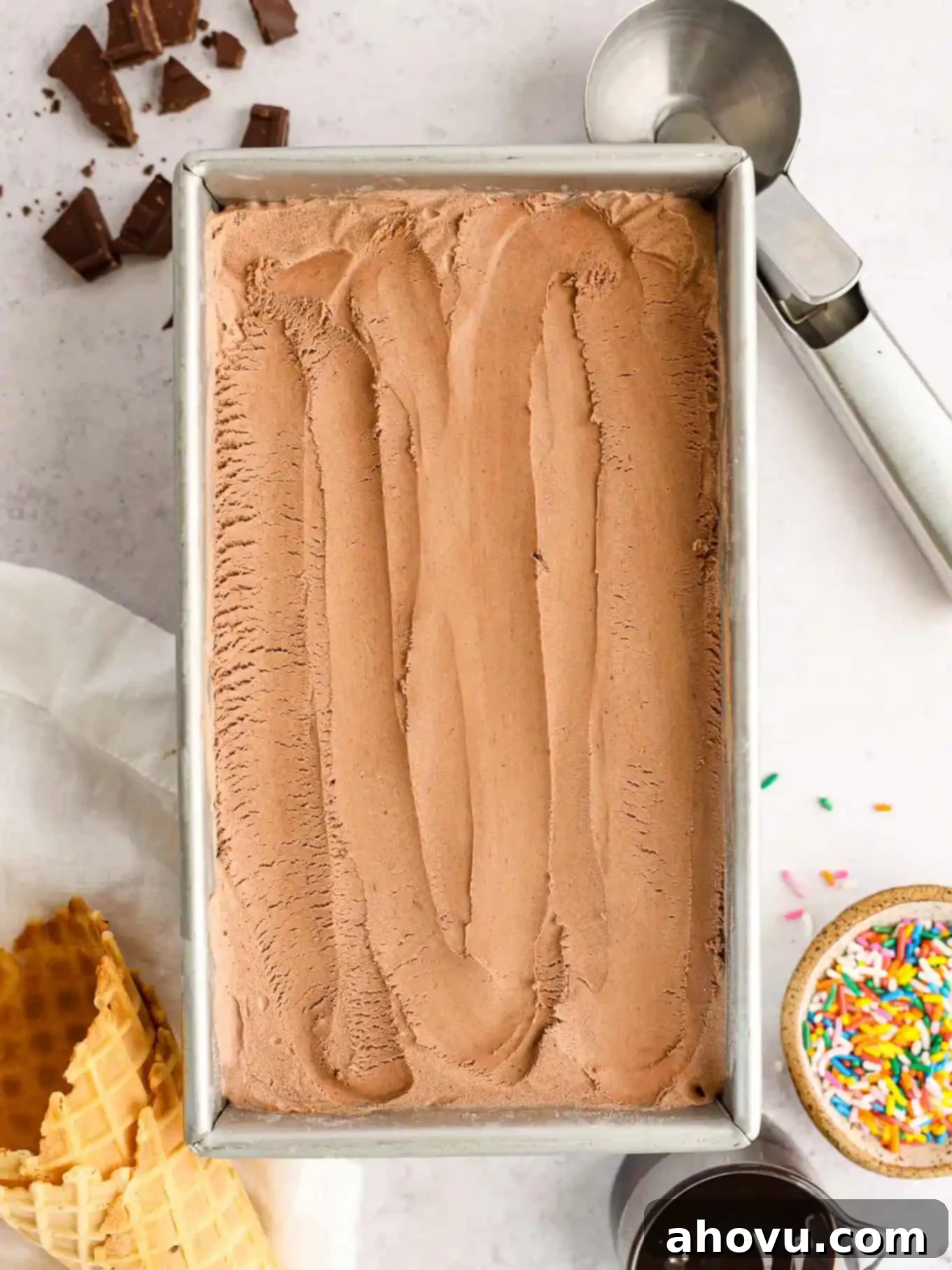 Decadent Chocolate Delight 8 An overhead view of rich homemade chocolate ice cream smoothly spread in a silver loaf pan, ready for freezing.
