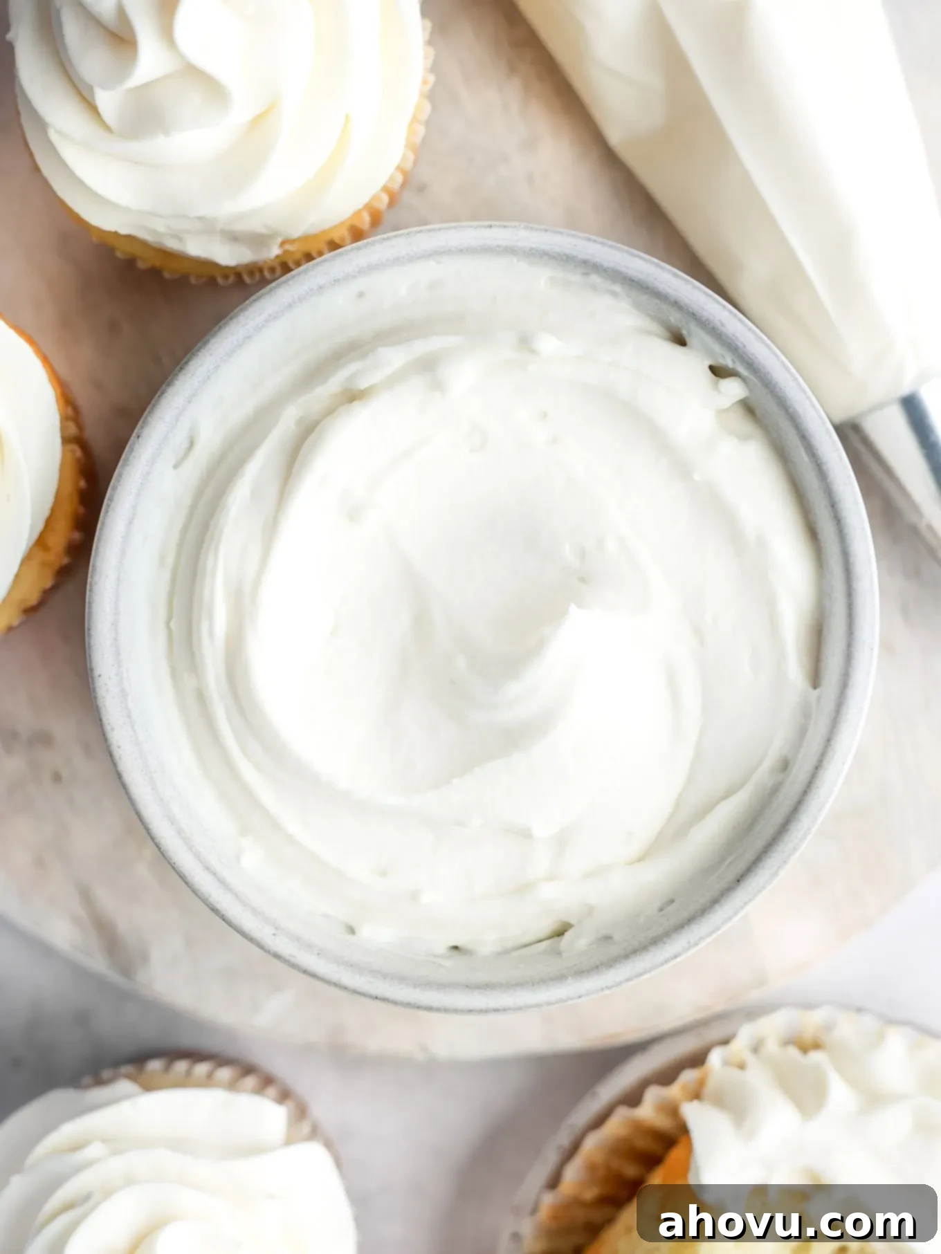 Overhead view of a finished bowl of whipped cream cheese frosting, ready to be used, highlighting its smooth and spreadable consistency.