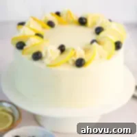 A lemon blueberry cake on a cake stand.