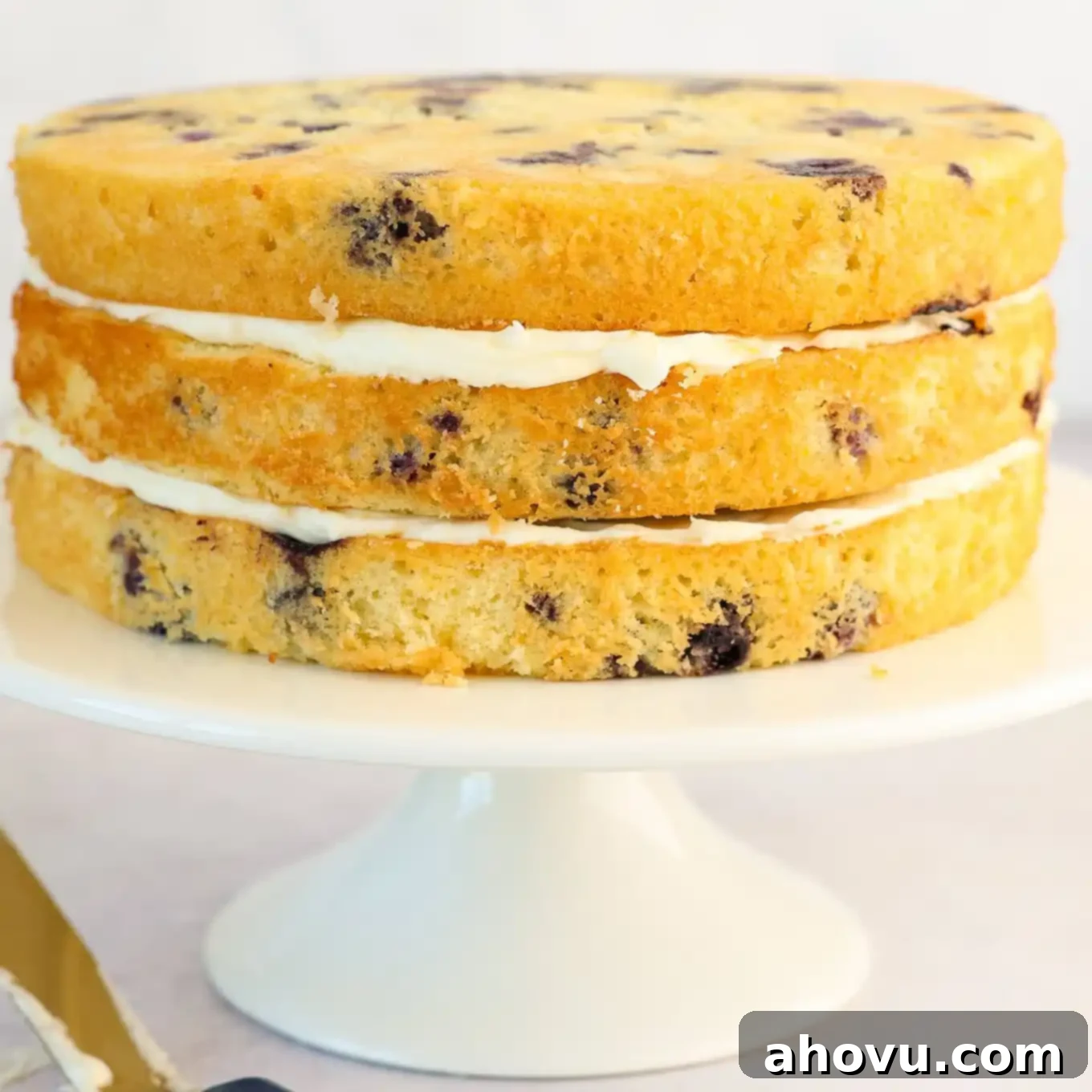 Three layers of moist lemon blueberry cake stacked with generous layers of lemon cream cheese frosting in between.