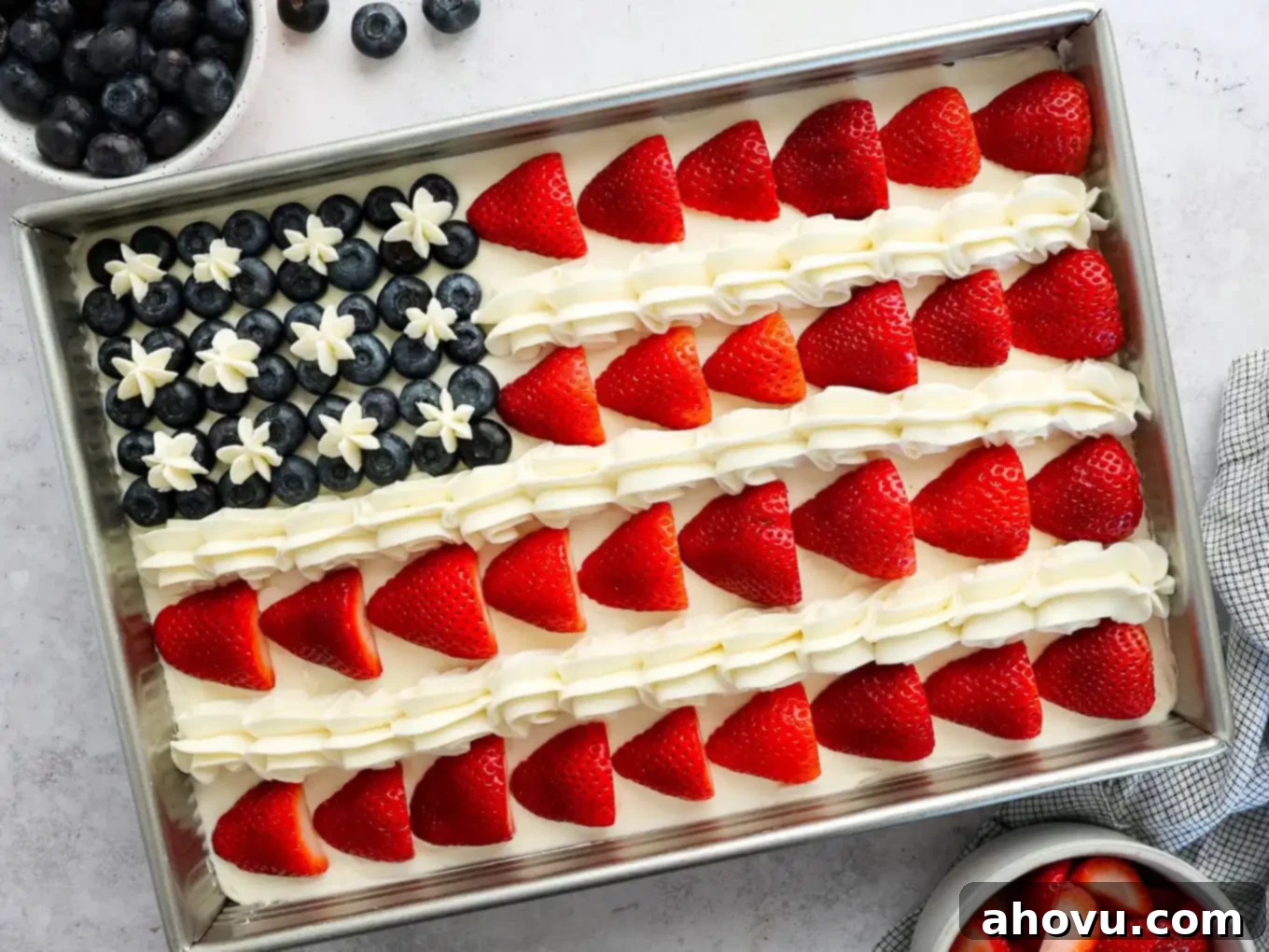 An American flag cake decorated with strawberries and blueberries, ready to be served.
