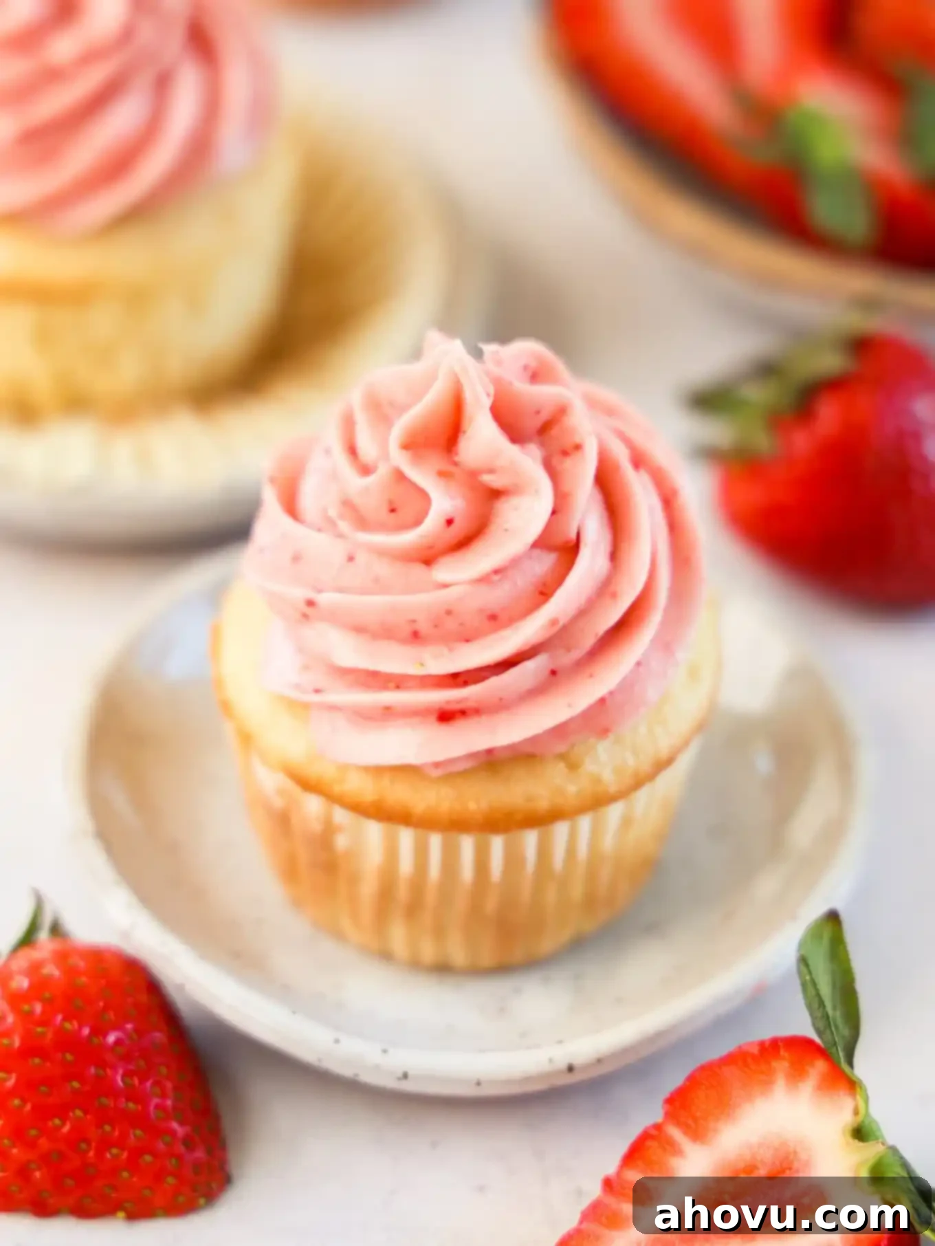 Dreamy Strawberry Cream Cheese Topping 2 A cupcake topped with strawberry cream cheese frosting, showcasing its vibrant pink hue and smooth texture.