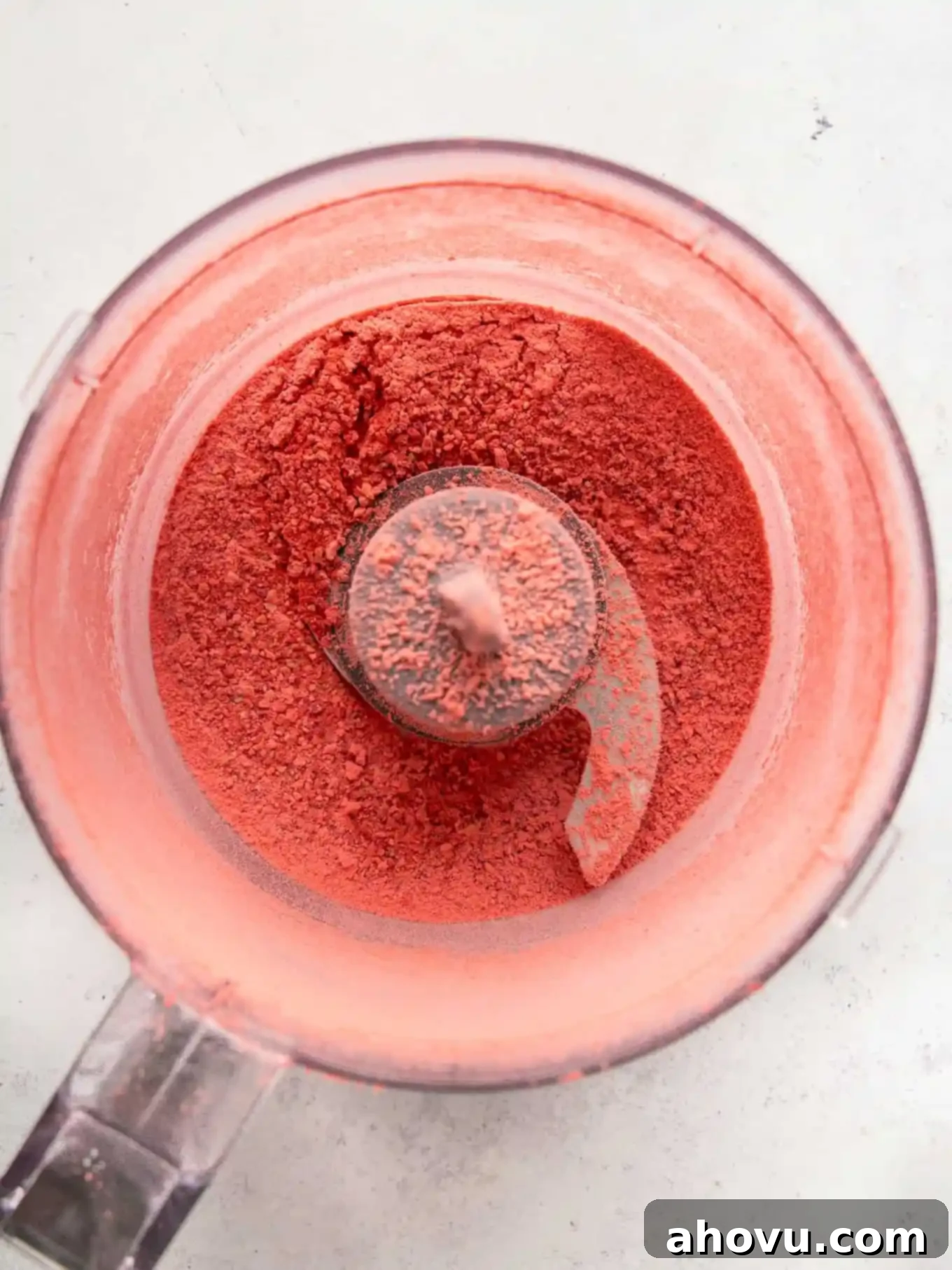 Dreamy Strawberry Cream Cheese Topping 4 Overhead view of fine freeze-dried strawberry powder in a food processor, ready for mixing.