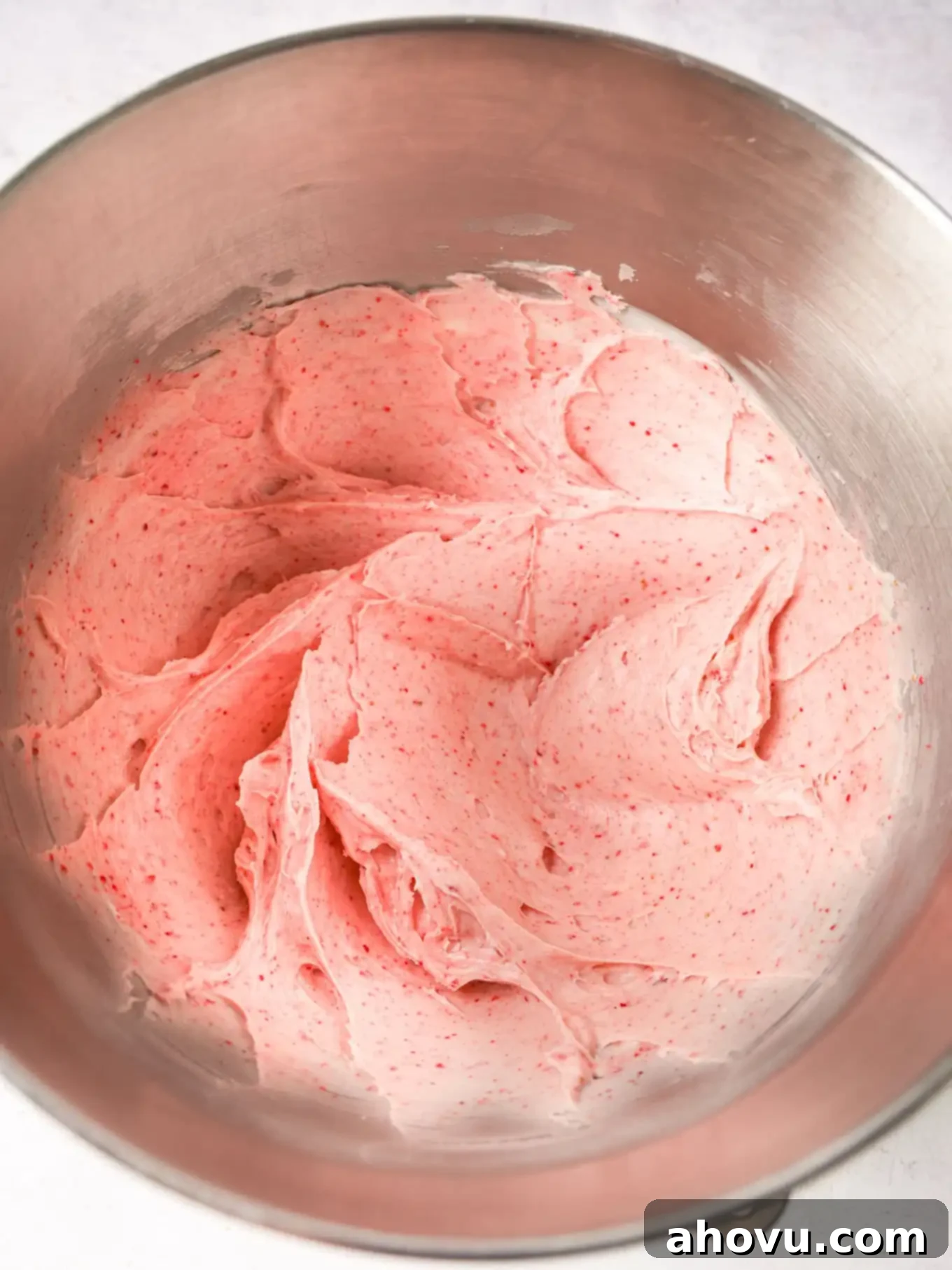 Dreamy Strawberry Cream Cheese Topping 6 Overhead view of freshly made strawberry cream cheese frosting in a mixing bowl, showing its creamy, vibrant texture.