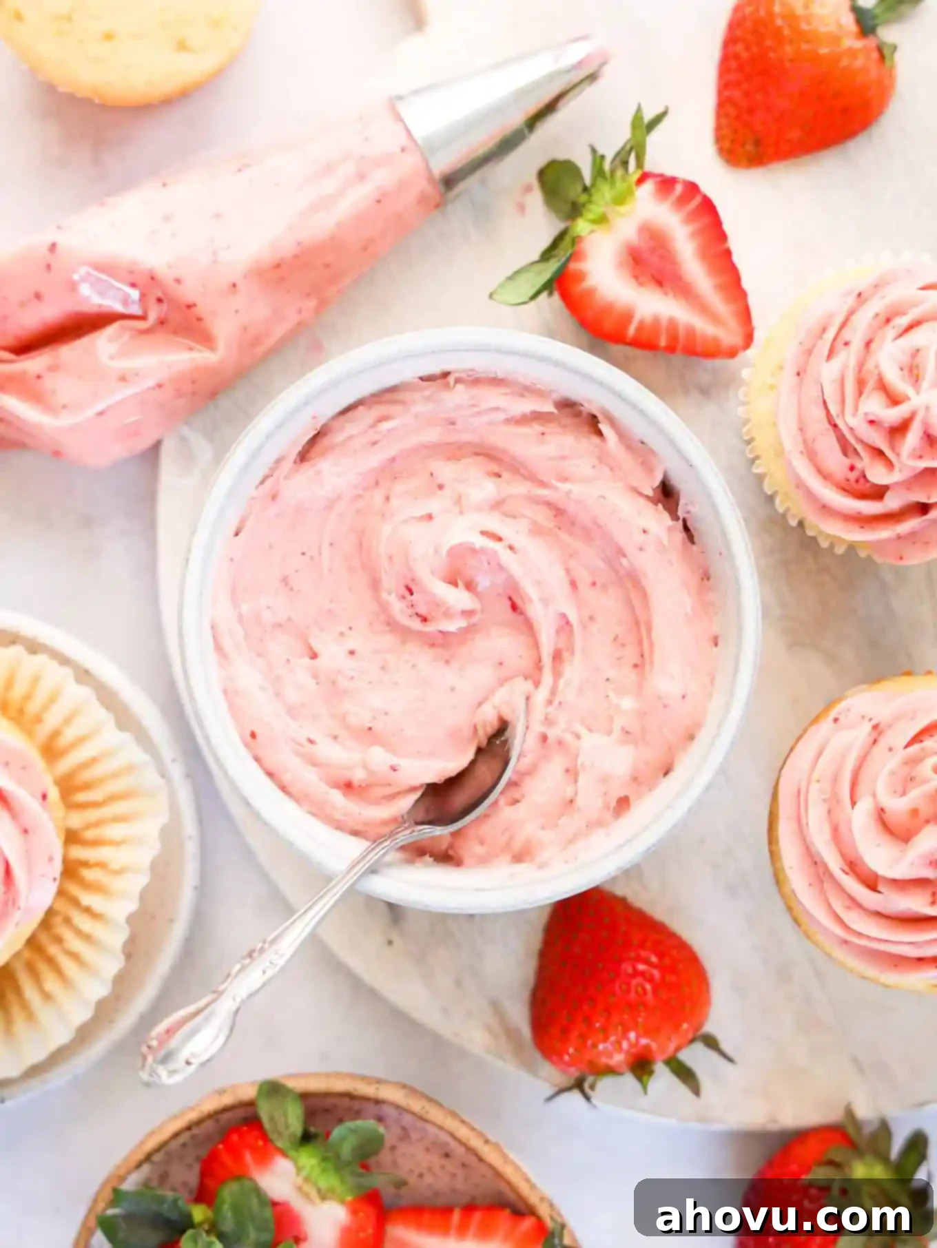 Dreamy Strawberry Cream Cheese Topping 8 A beautifully arranged spread of strawberry cream cheese frosting, frosted cupcakes, fresh berries, and a piping bag, ready for dessert.