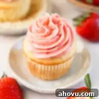Dreamy Strawberry Cream Cheese Topping 9 A cupcake topped with strawberry cream cheese frosting, ready to be enjoyed.