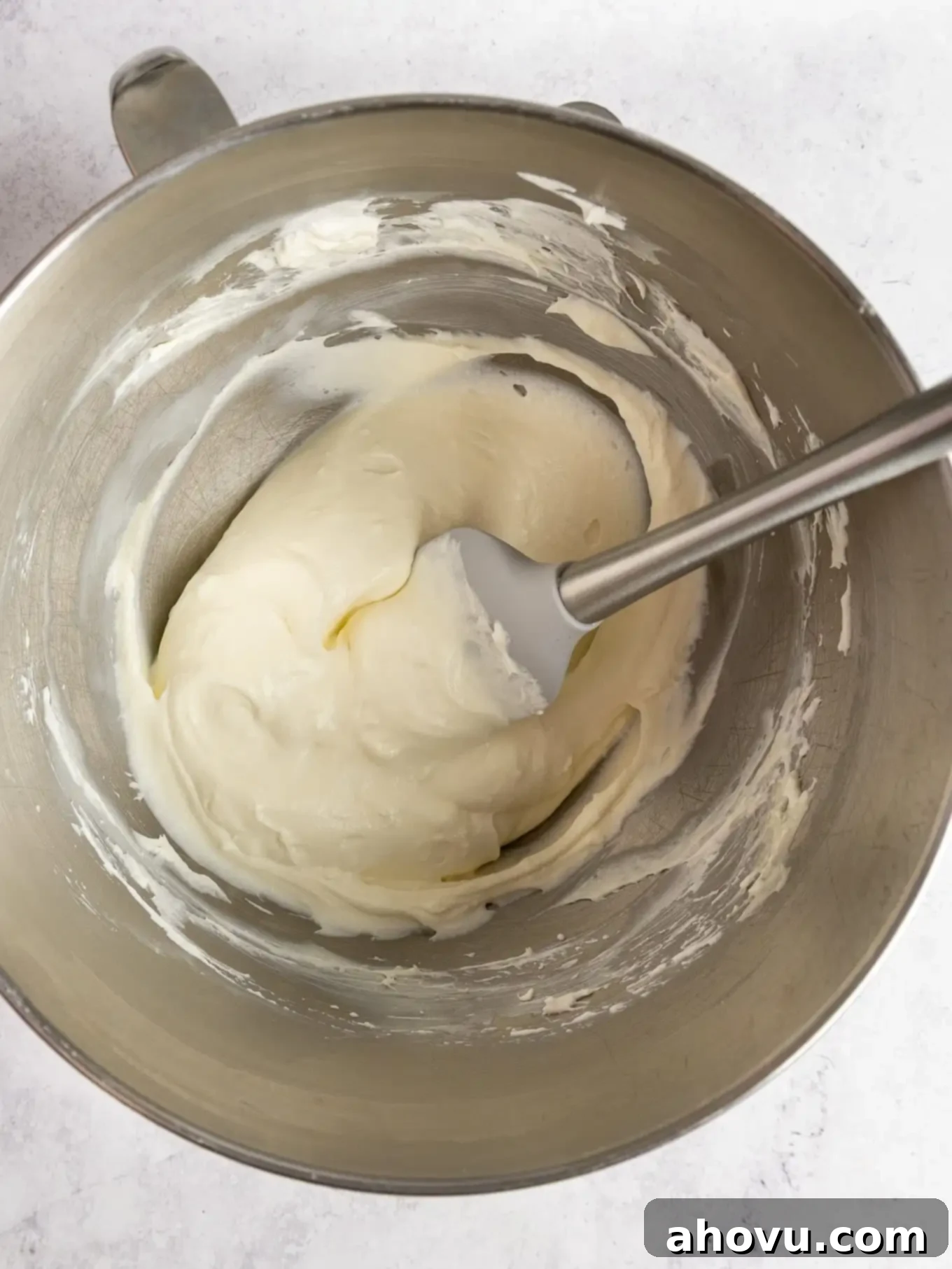 An overhead view of the smooth, creamy no-bake cheesecake filling in a mixing bowl, showcasing its light and airy texture.