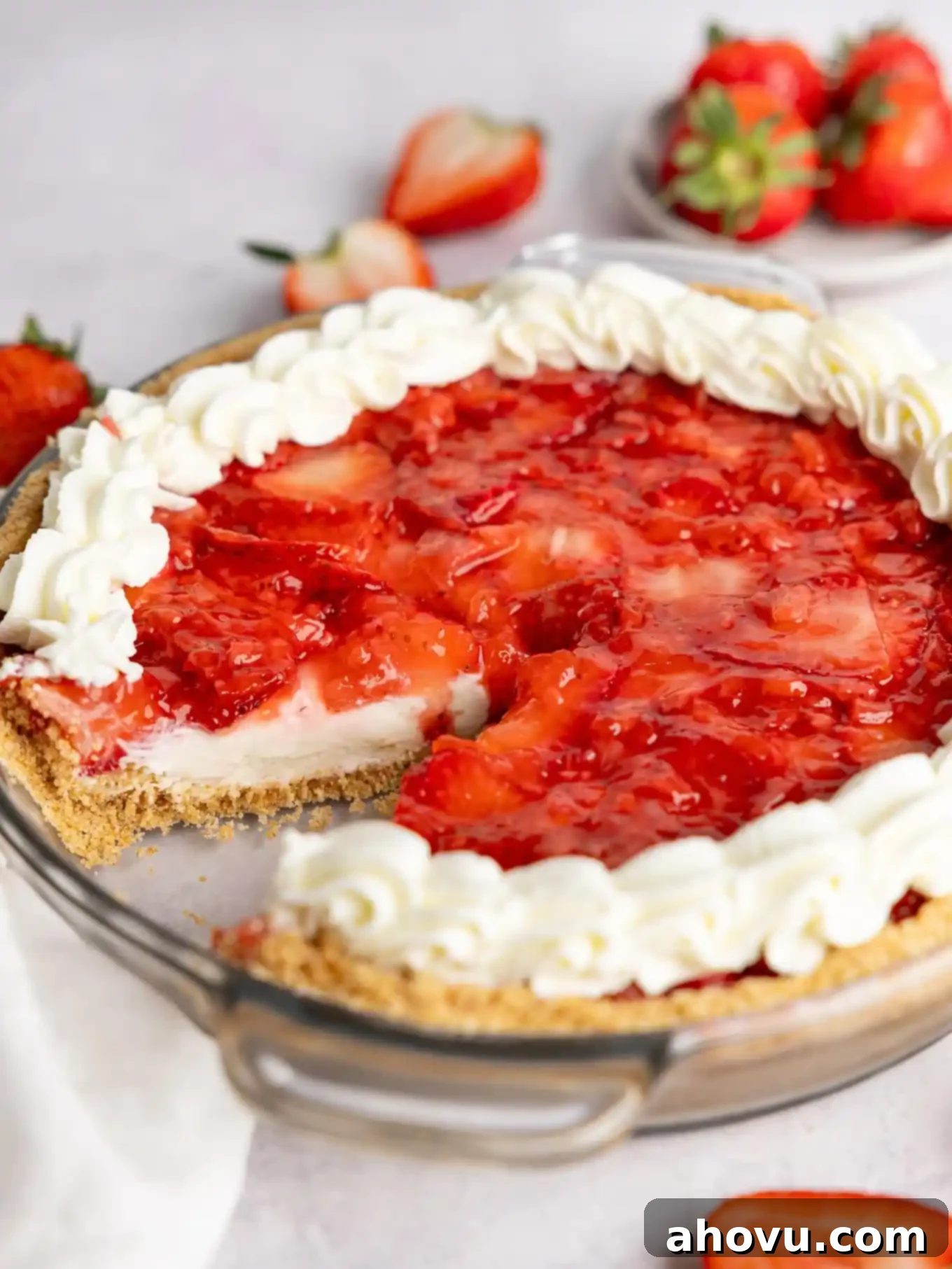 A beautifully set no-bake strawberry cream cheese pie, with a perfect slice removed, showcasing its creamy filling and vibrant strawberry layers.