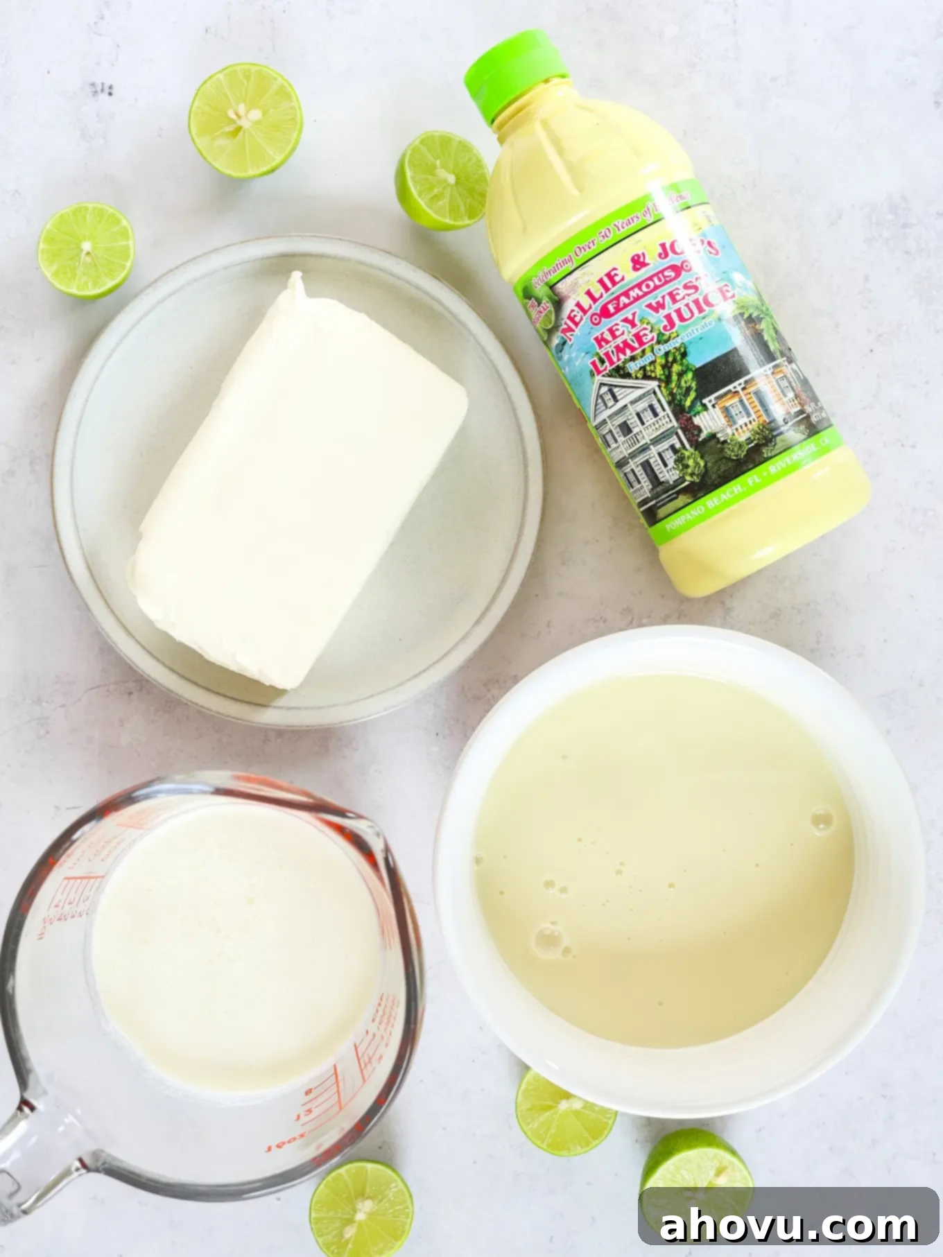 A collection of essential ingredients laid out for making the no-bake key lime pie, including key lime juice, cream cheese, and graham crackers.
