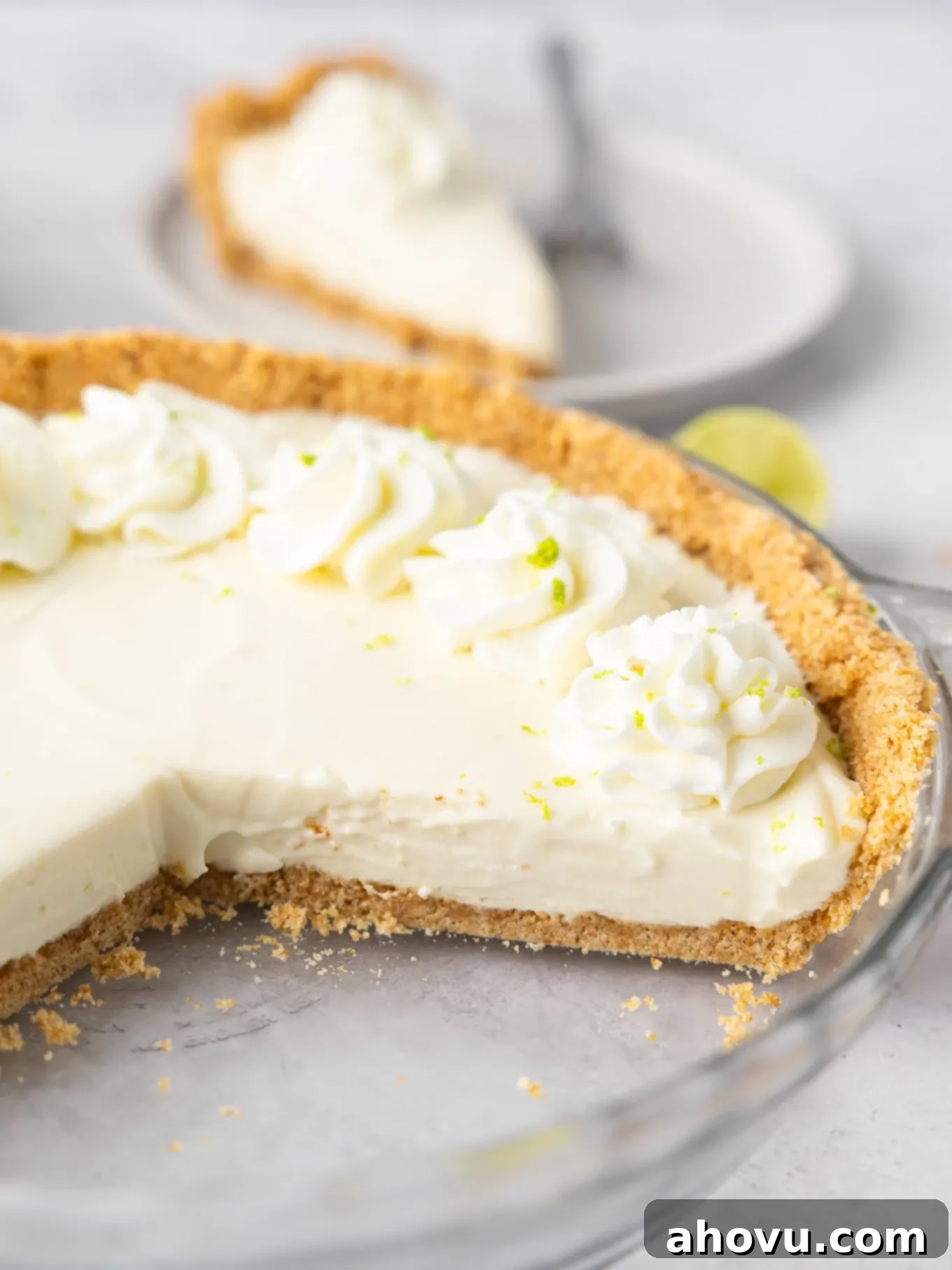 A freshly sliced no-bake key lime pie on a cutting board, revealing its creamy texture and distinct layers.