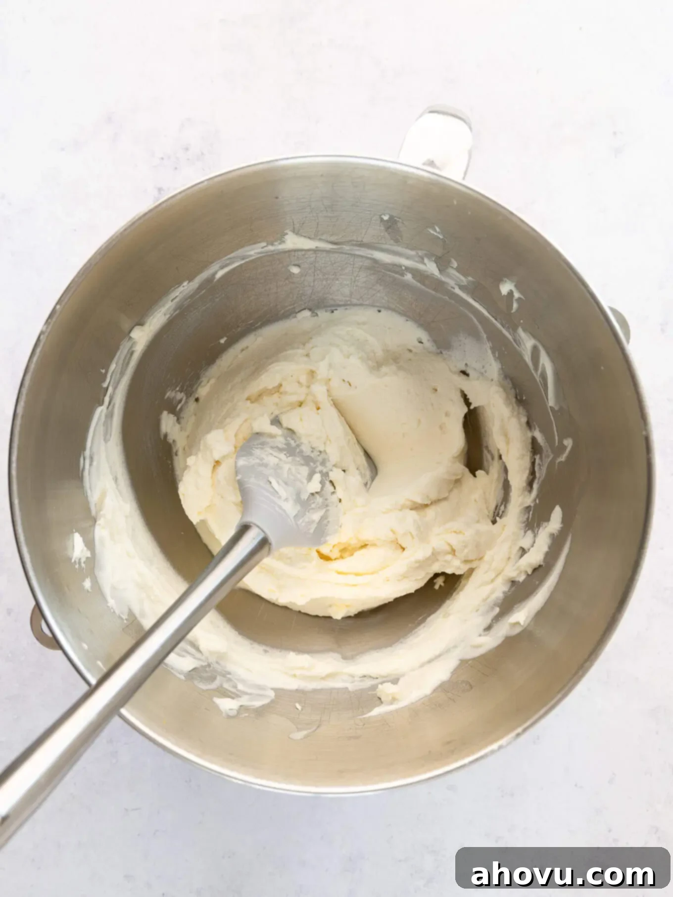 An overhead view of mascarpone frosting in the bowl of a stand mixer. 