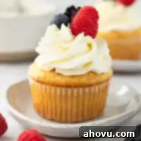 A vanilla cupcake topped with mascarpone frosting and fresh berries.