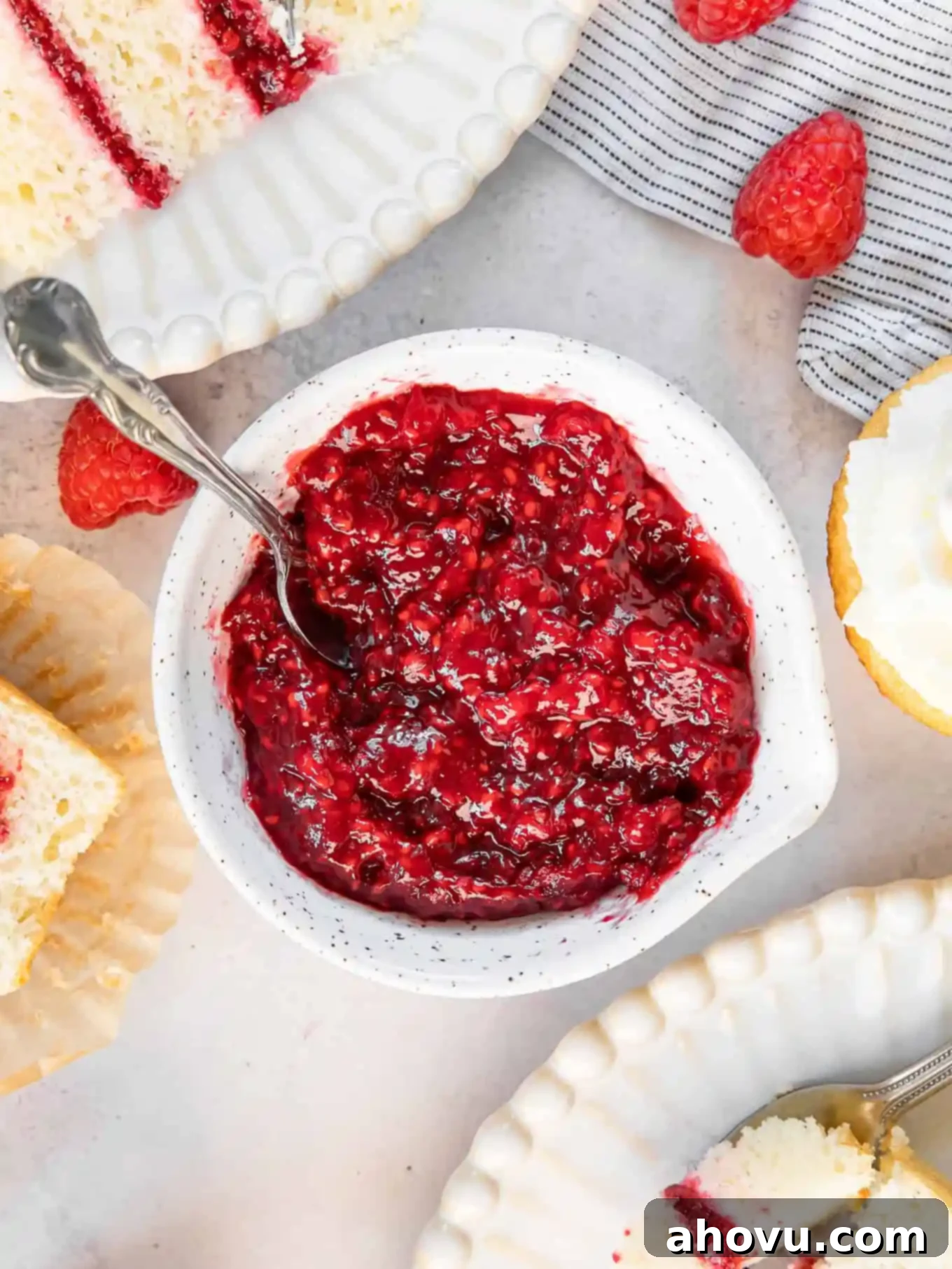 A vibrant red dish of freshly made raspberry cake filling, thick and glossy, ready to be used.