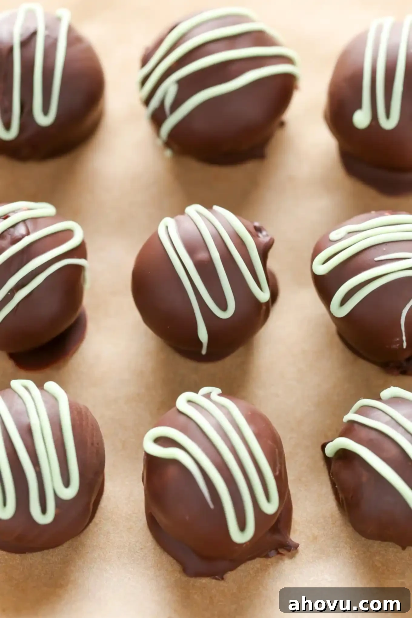 Close-up of freshly rolled mint chocolate truffle ganache balls on parchment paper, ready for coating.