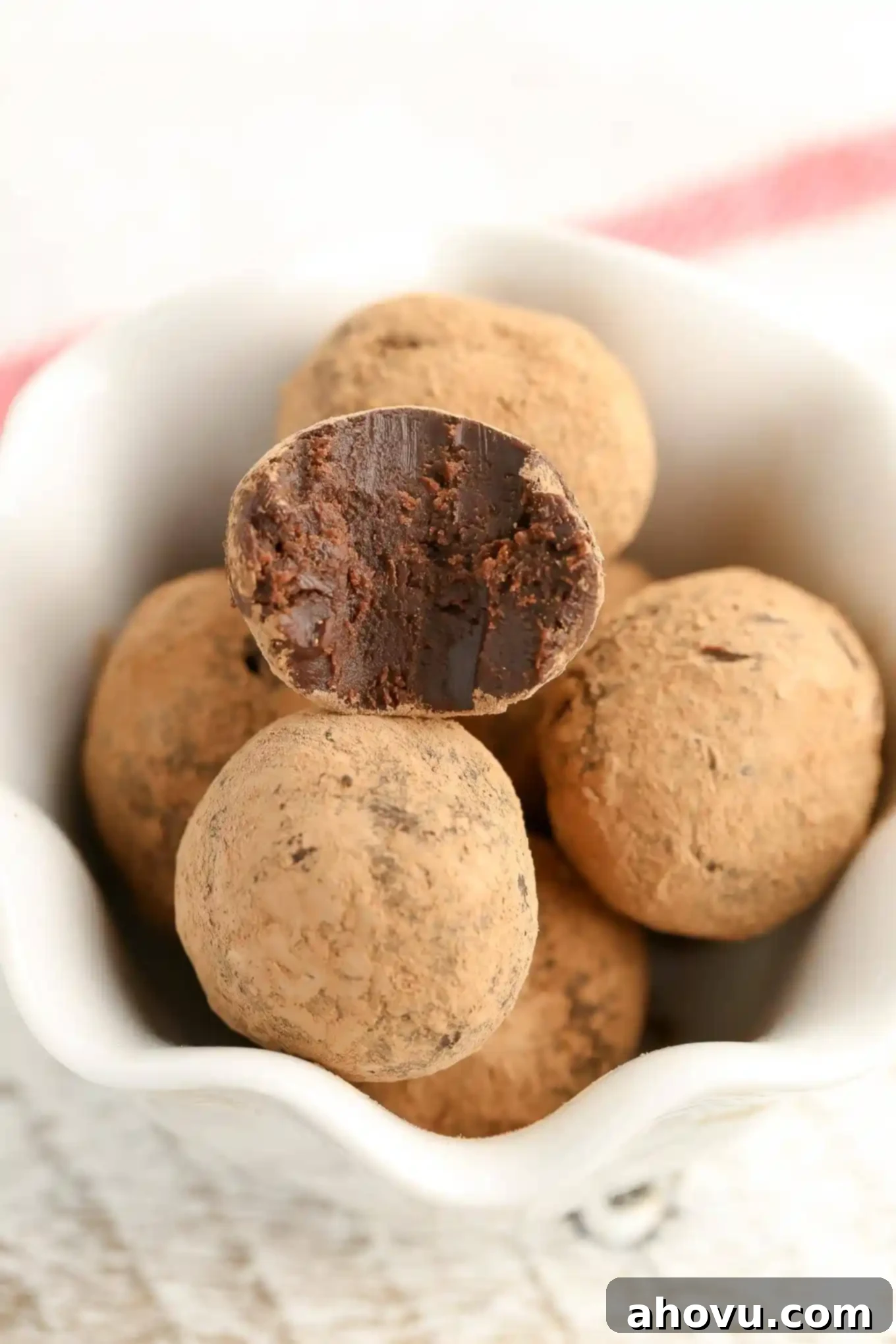 Hands rolling a mint chocolate truffle ball, demonstrating the shaping process.