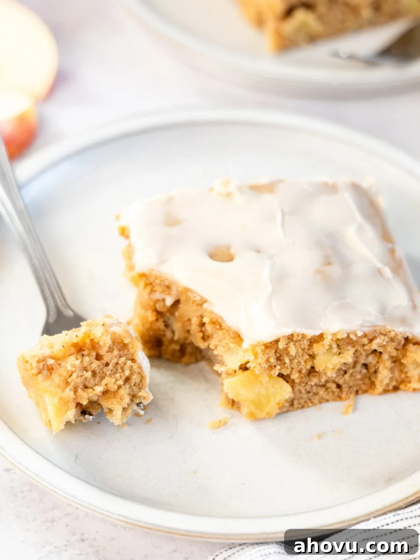 A slice of apple fritter cake, with a piece speared on a fork. 