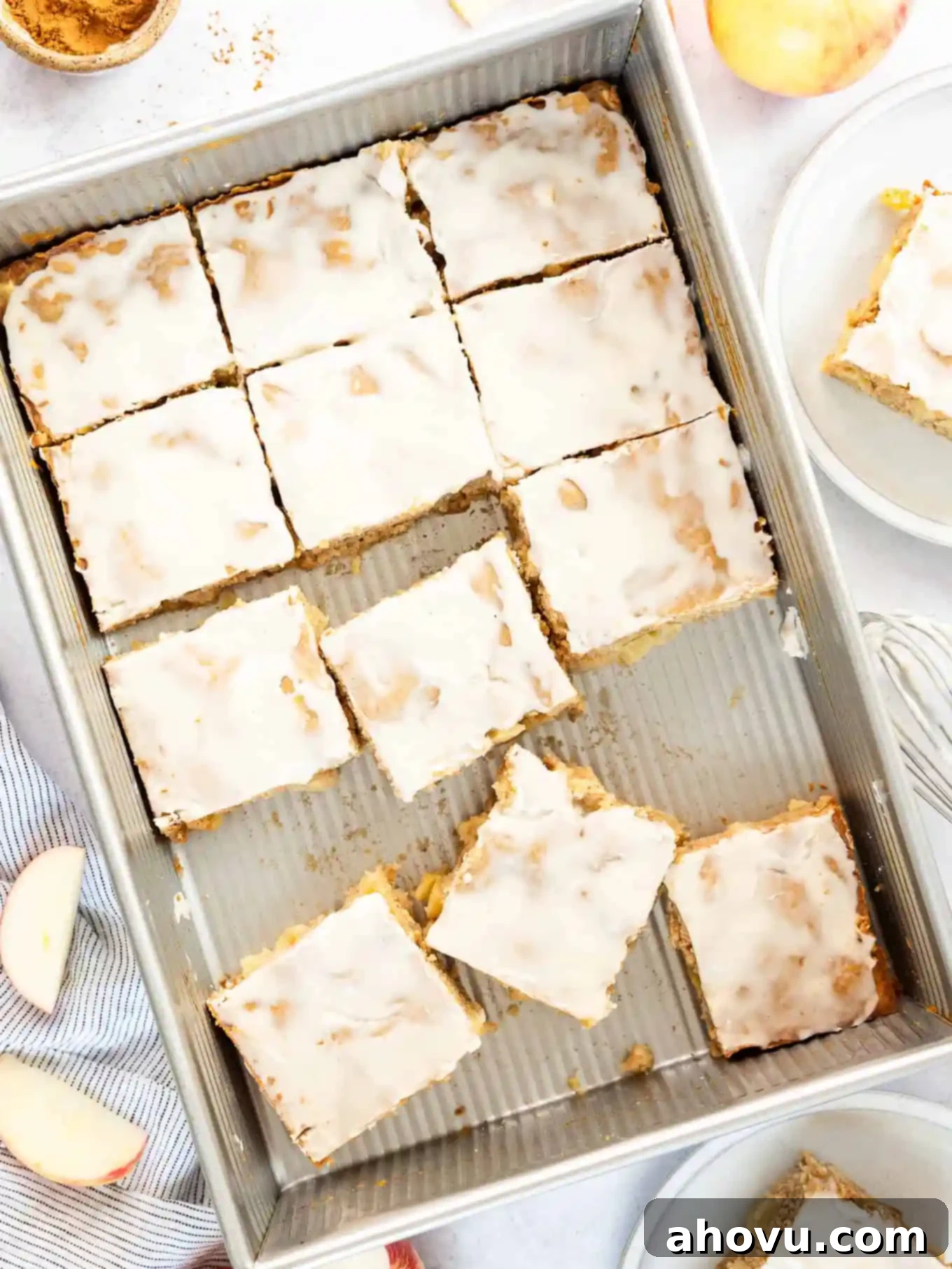 A sliced apple fritter cake in a 9x13 pan. 