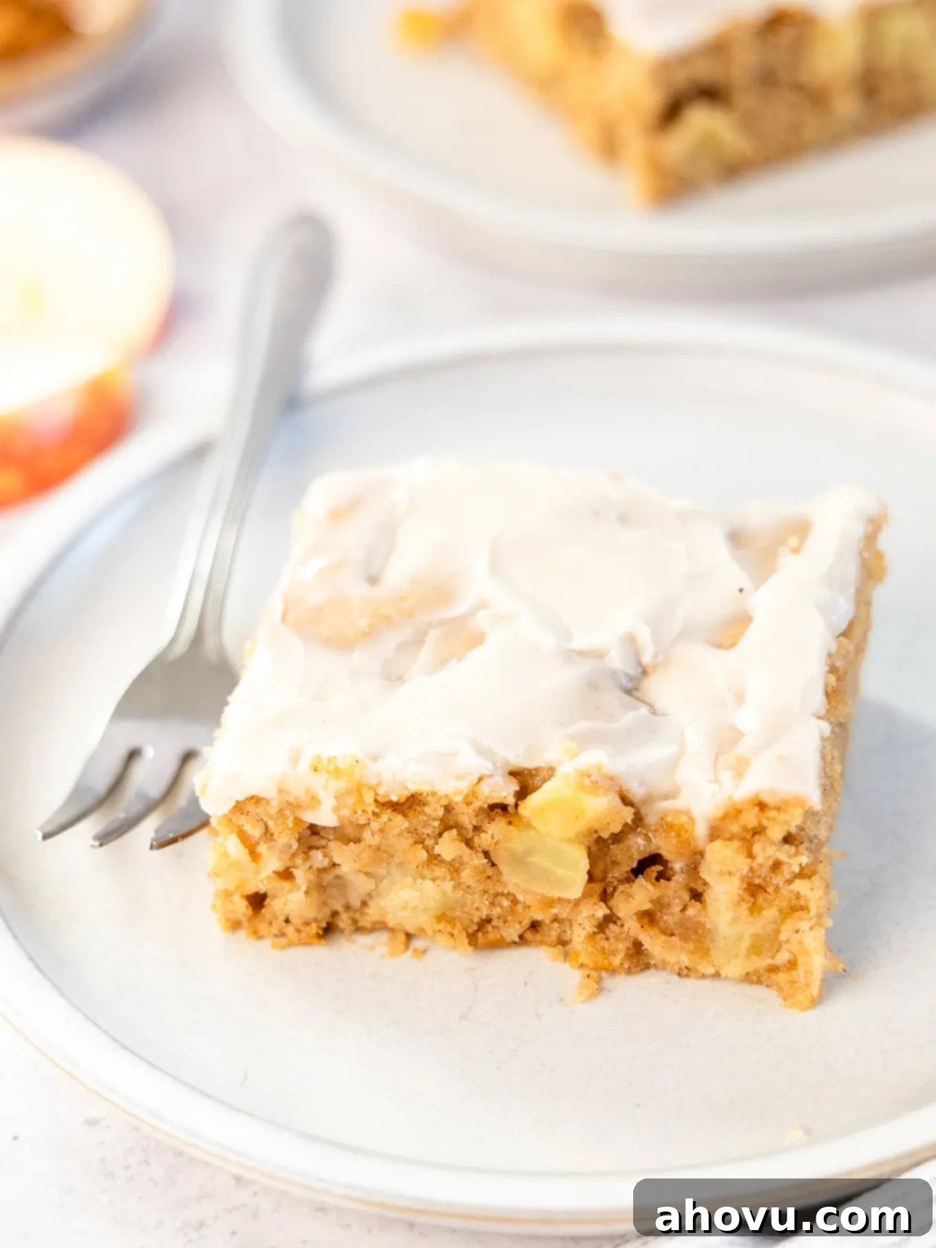 A slice of apple fritter cake with a fork. 