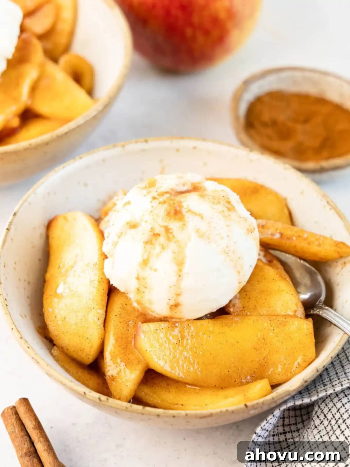 A bowl of fried apples topped with ice cream. 