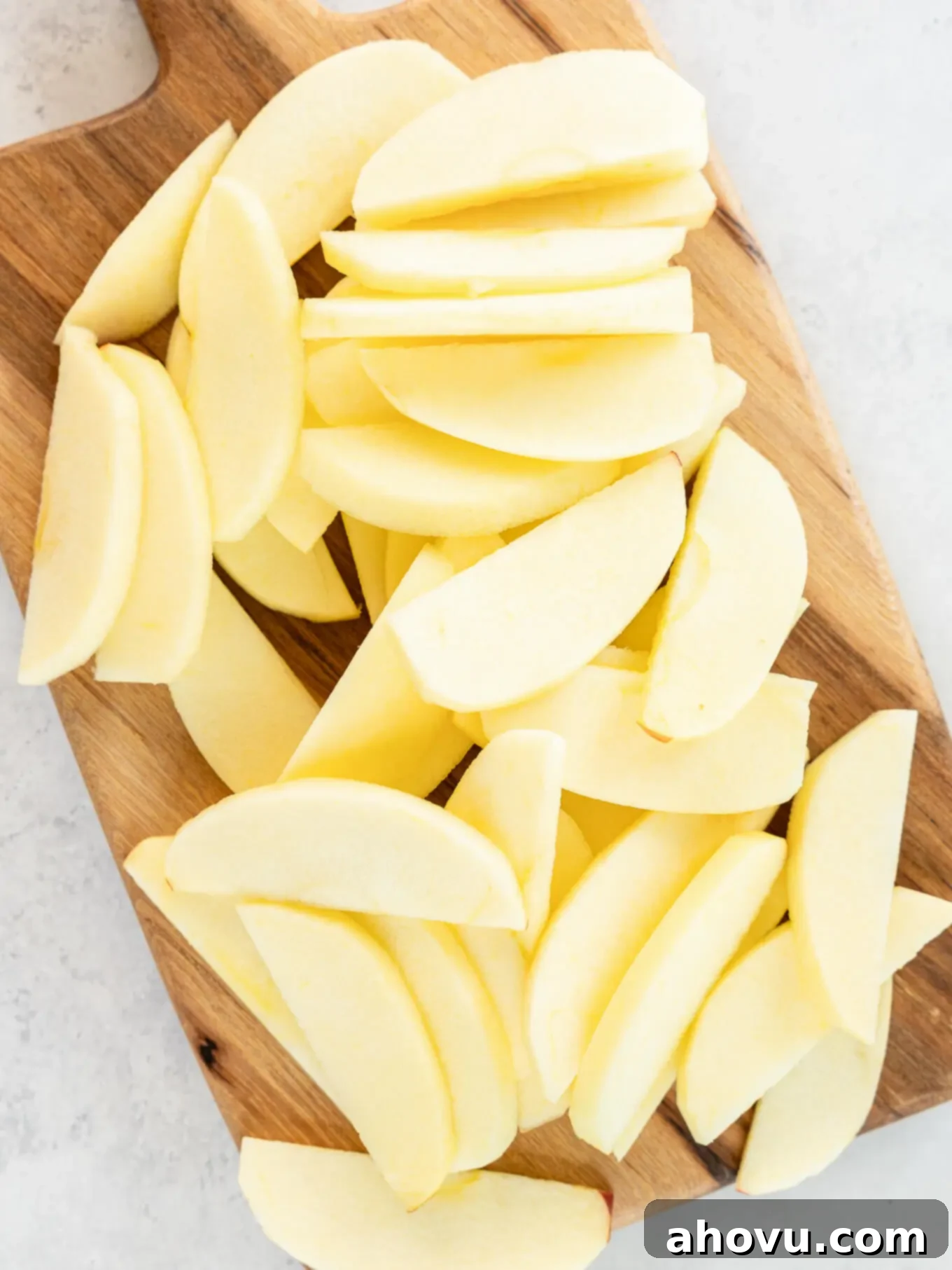 Peeled, sliced apples on a cutting board. 