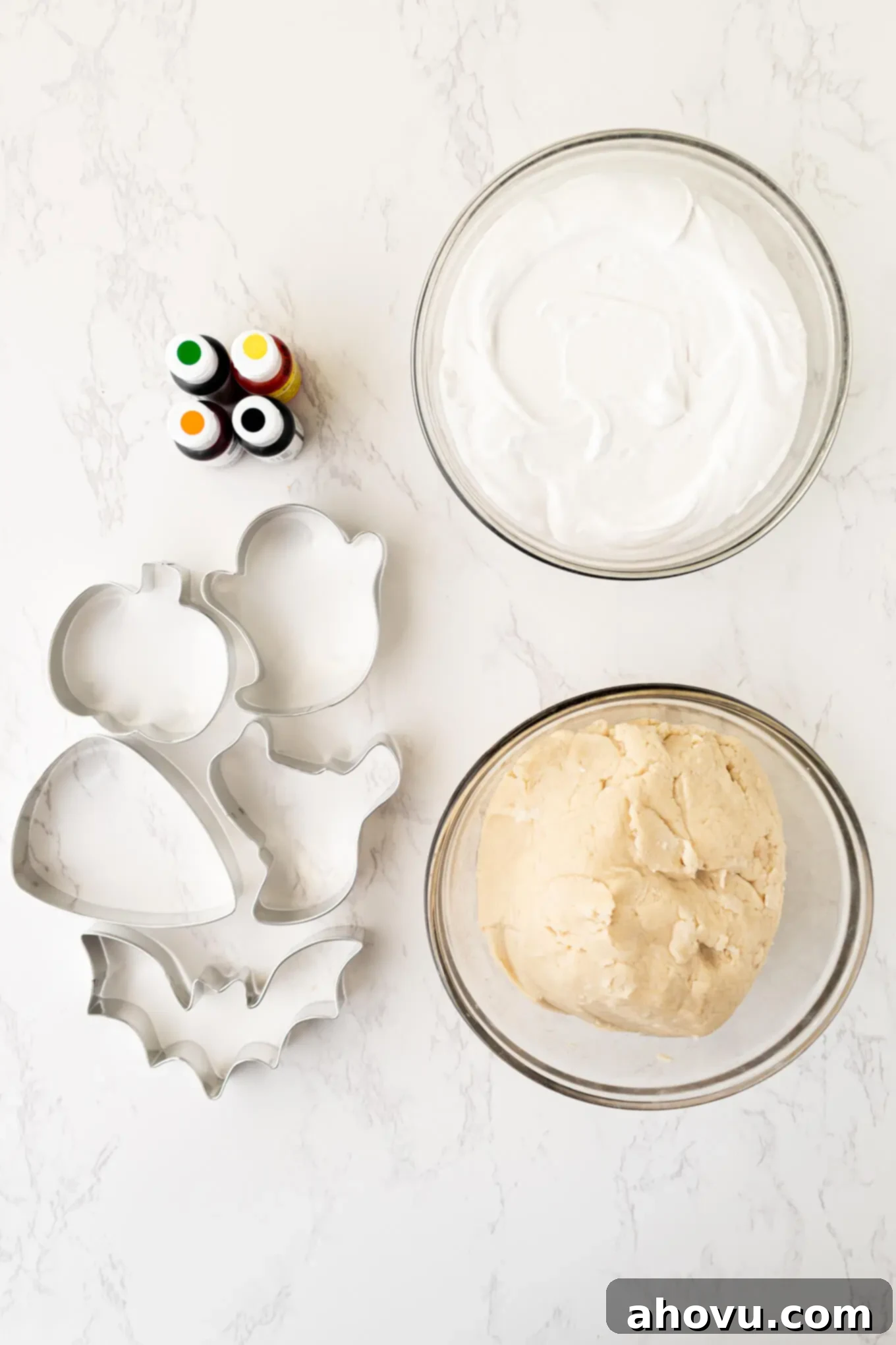 Frightfully Delicious Halloween Treats 3 An overhead view of essential baking supplies laid out for making Halloween sugar cookies, including cookie cutters, piping bags, and colorful gel food coloring.