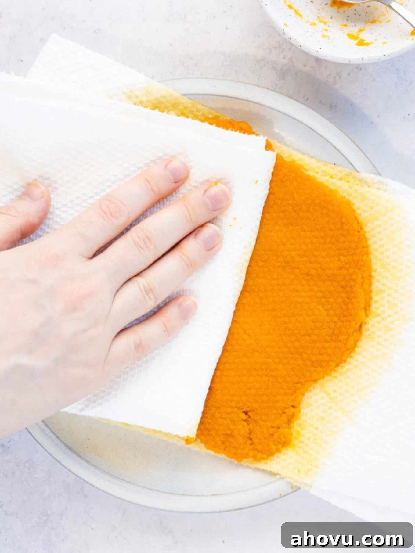 Pumpkin Spice Fudge 5 An overhead view depicting more paper towels being pressed firmly onto pumpkin puree, actively blotting away moisture.