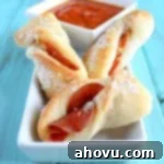 Close-up of baked pepperoni breadsticks on parchment paper