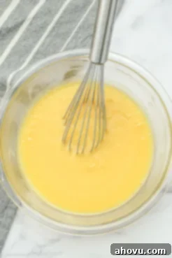 A clear mixing bowl containing the wet ingredients for fudgy homemade brownies, ready for dry ingredients.
