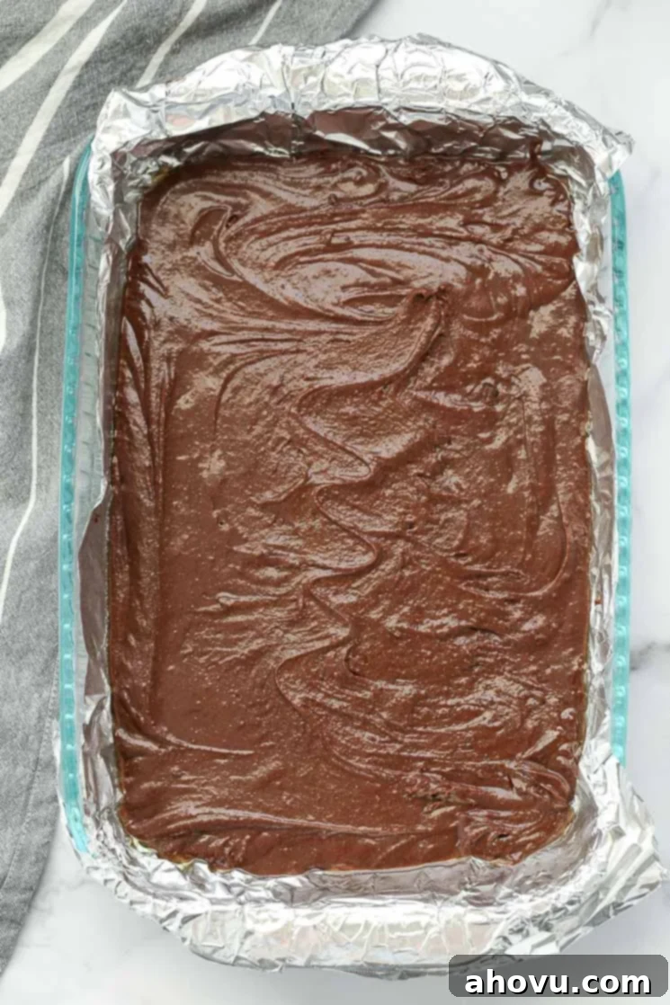 Heavenly Homemade Brownies 4 A baking pan meticulously lined with aluminum foil, evenly filled with smooth homemade brownie batter, ready for the oven.