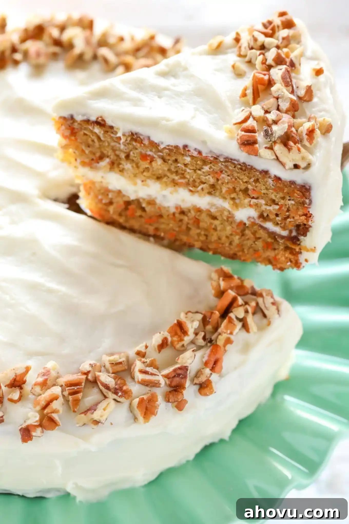 Irresistible Carrot Cake Delight 14 A tempting slice of carrot cake being carefully lifted up, clearly showcasing its moist, tender texture and generous amount of frosting.
