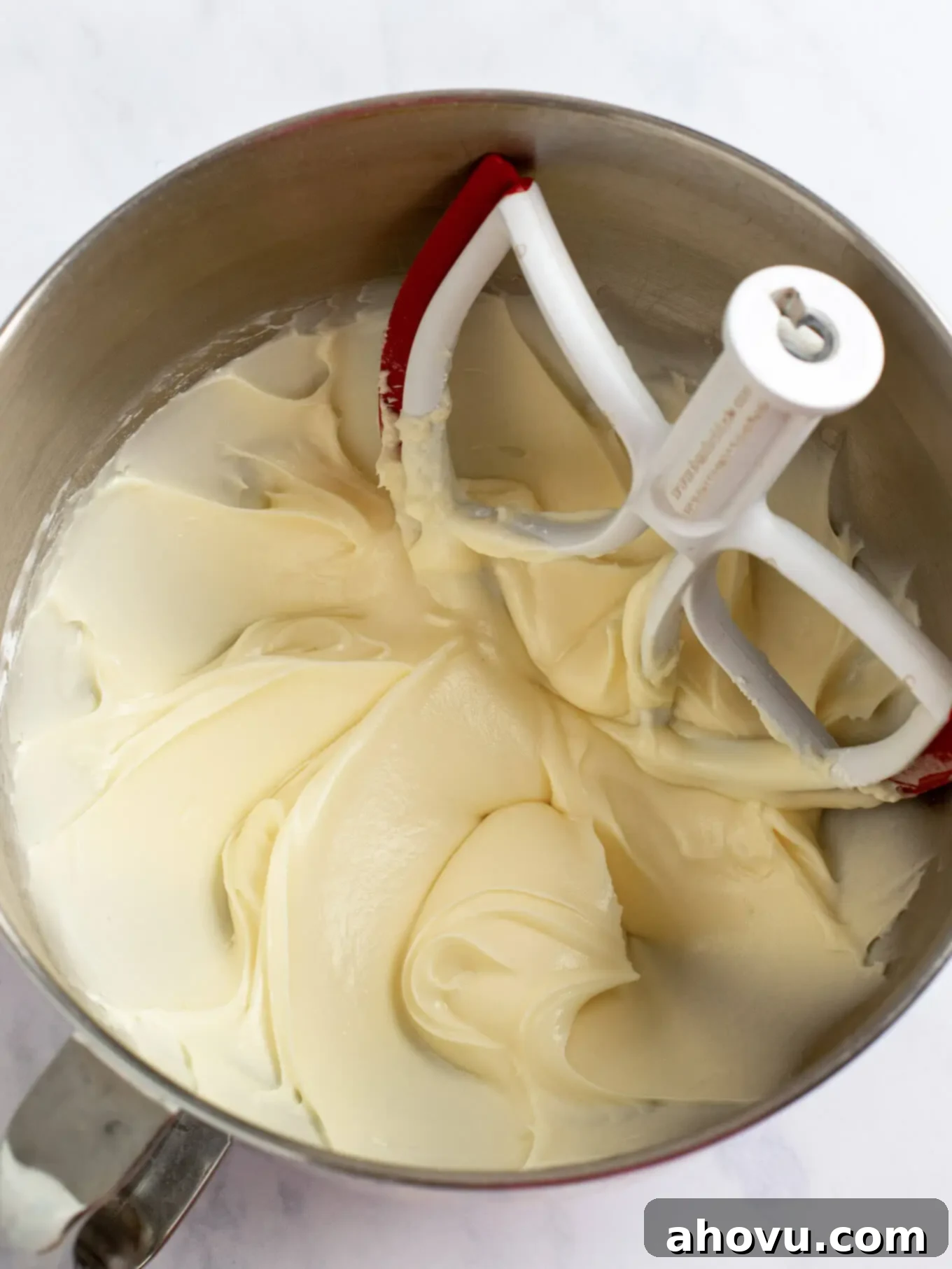 Irresistible Carrot Cake Delight 10 The luxurious cream cheese frosting, perfectly mixed and smooth, filling the bowl of a stand mixer, ready to adorn the carrot cake.