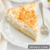 A close-up image of a slice of coconut cream pie on a plate, highlighting its creamy filling, whipped topping, and toasted coconut.