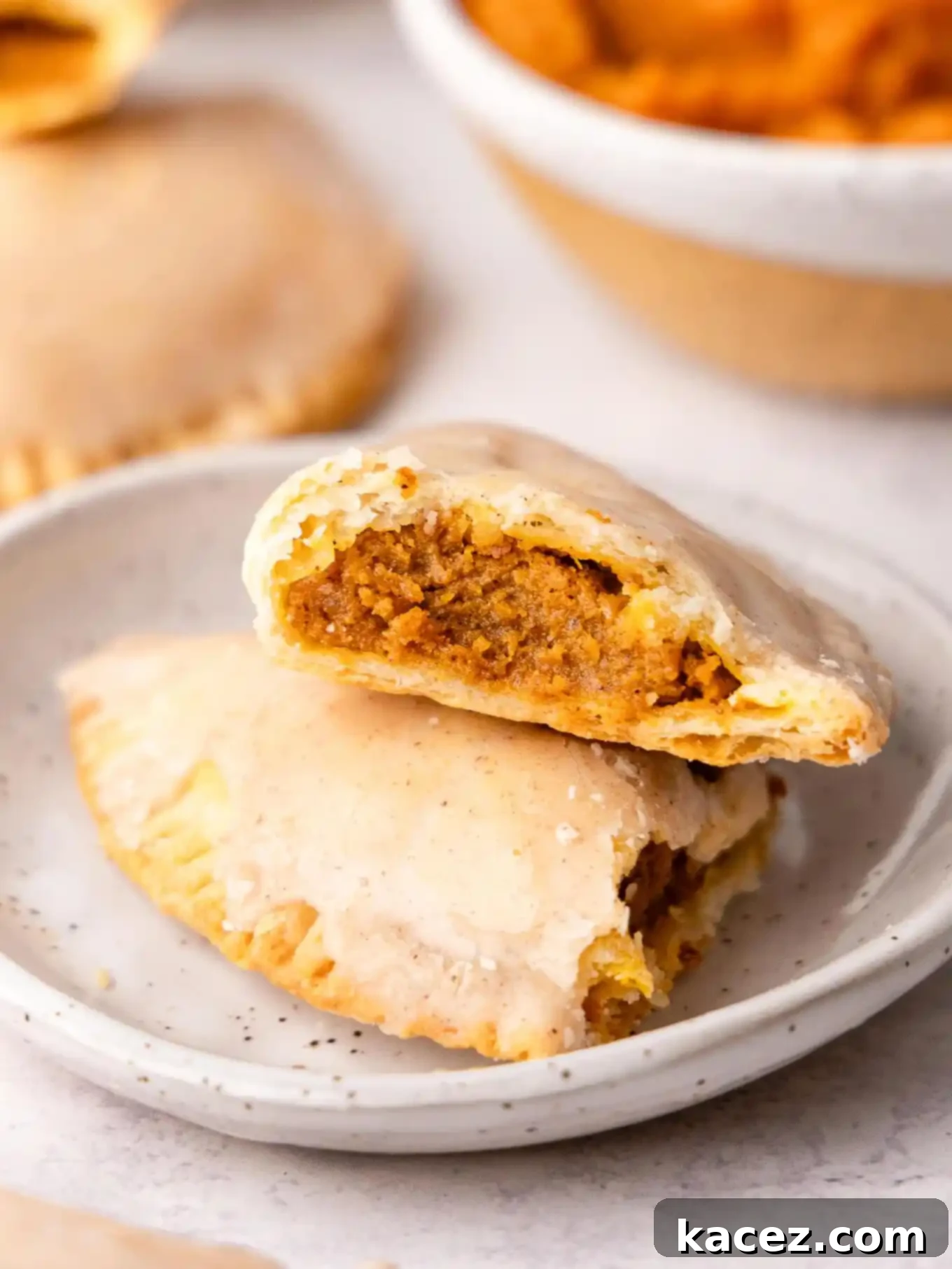 Spiced Pumpkin Pastries 2 A pumpkin hand pie, broken in half, showcasing the rich pumpkin filling and flaky crust.