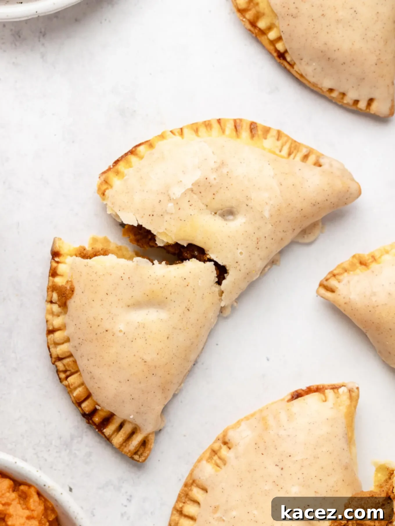 Spiced Pumpkin Pastries 12 An overhead view of a pumpkin hand pie broken in two, with the steam still rising from the warm filling.