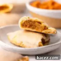 Spiced Pumpkin Pastries 13 A pumpkin hand pie cut in half on a plate.