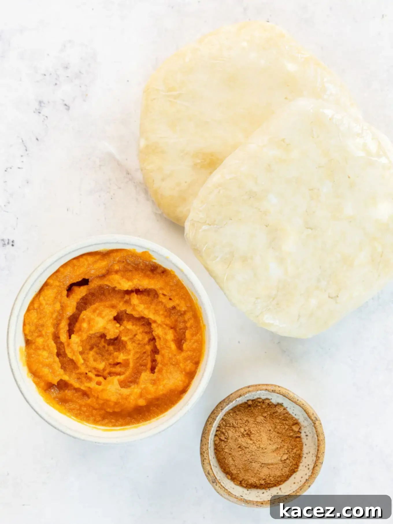 Spiced Pumpkin Pastries 3 An overhead view of key pumpkin hand pie ingredients: pumpkin puree, pumpkin pie spice, and pie dough.