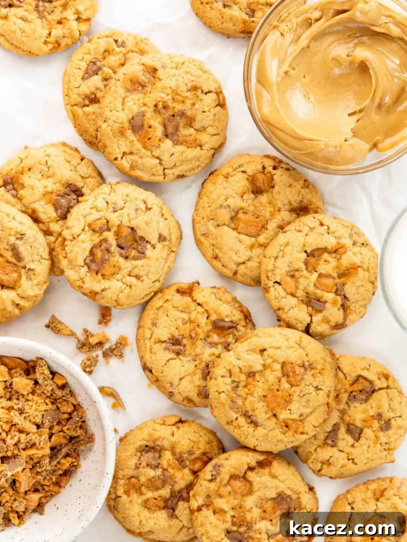 Sweet & Crunchy Butterfinger Treats 2 An overhead view of freshly baked Butterfinger cookies, with a small bowl of creamy peanut butter and a pile of crushed Butterfingers on the side, highlighting the key flavors and textures.