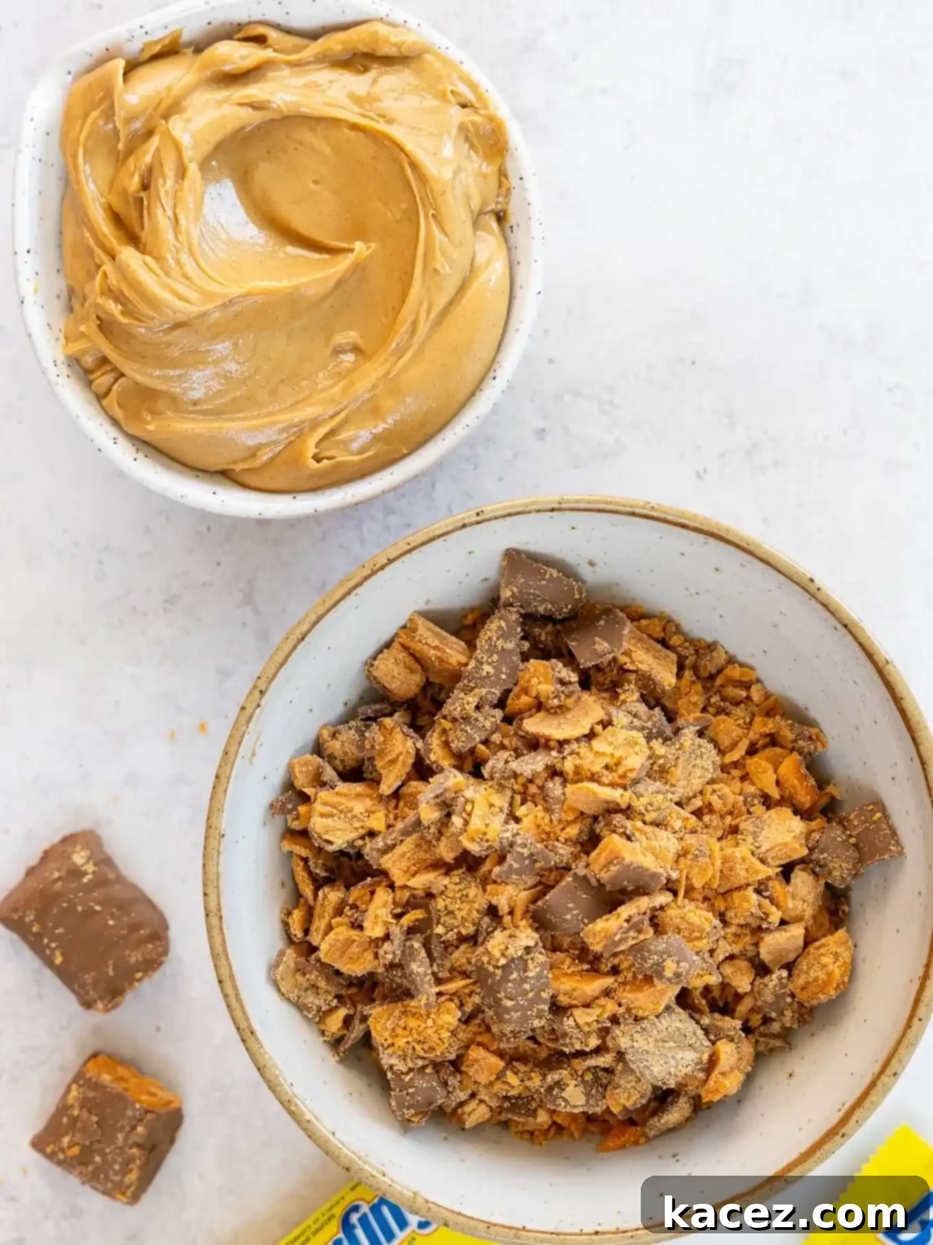 Sweet & Crunchy Butterfinger Treats 3 An overhead shot showcasing two small bowls; one filled with creamy peanut butter and the other with a generous amount of finely crushed Butterfingers, ready for baking.