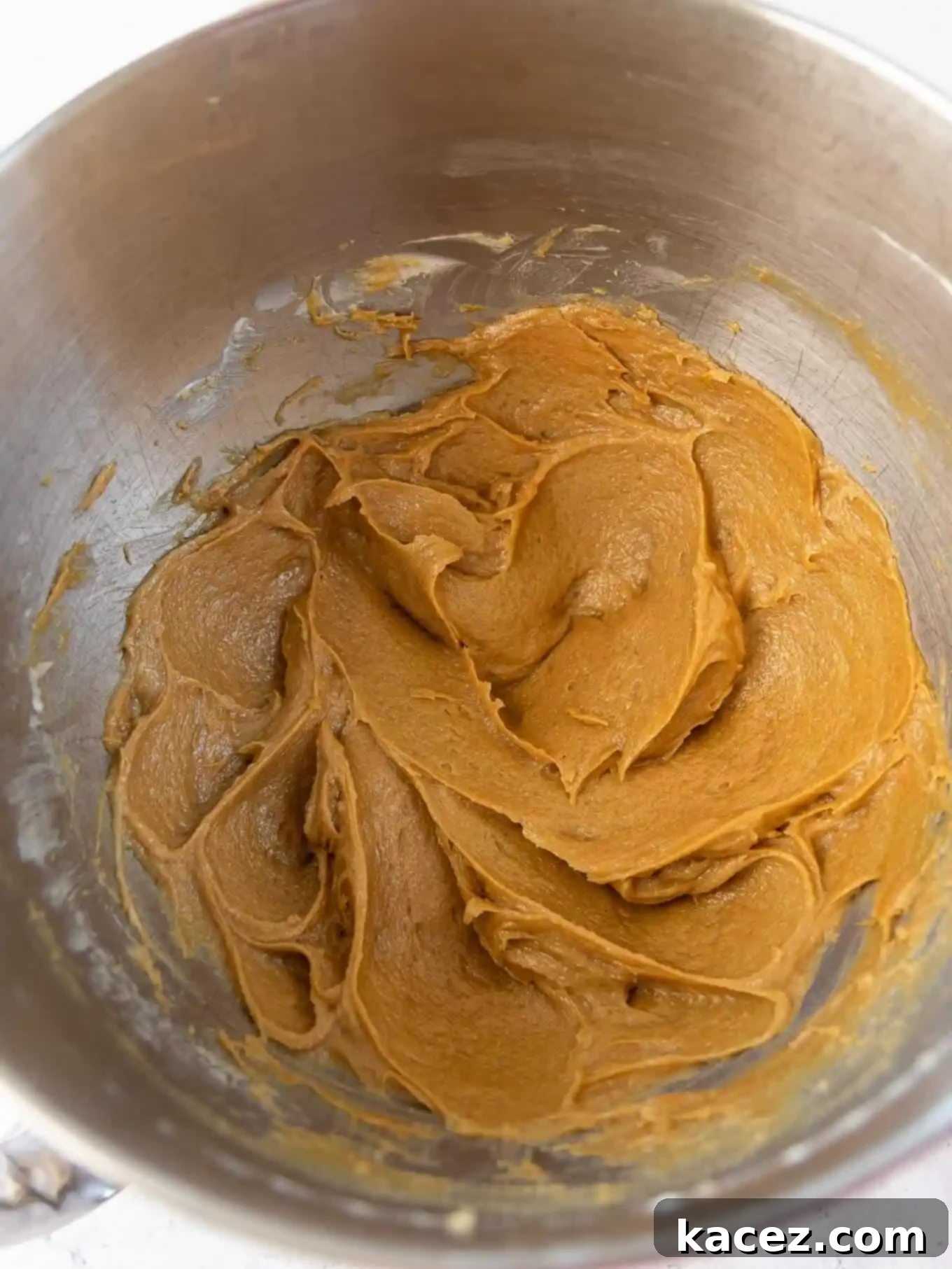 Sweet & Crunchy Butterfinger Treats 4 An overhead view of the creamy peanut butter and sugar mixture being creamed together in the bowl of a stand mixer, showcasing its smooth texture.