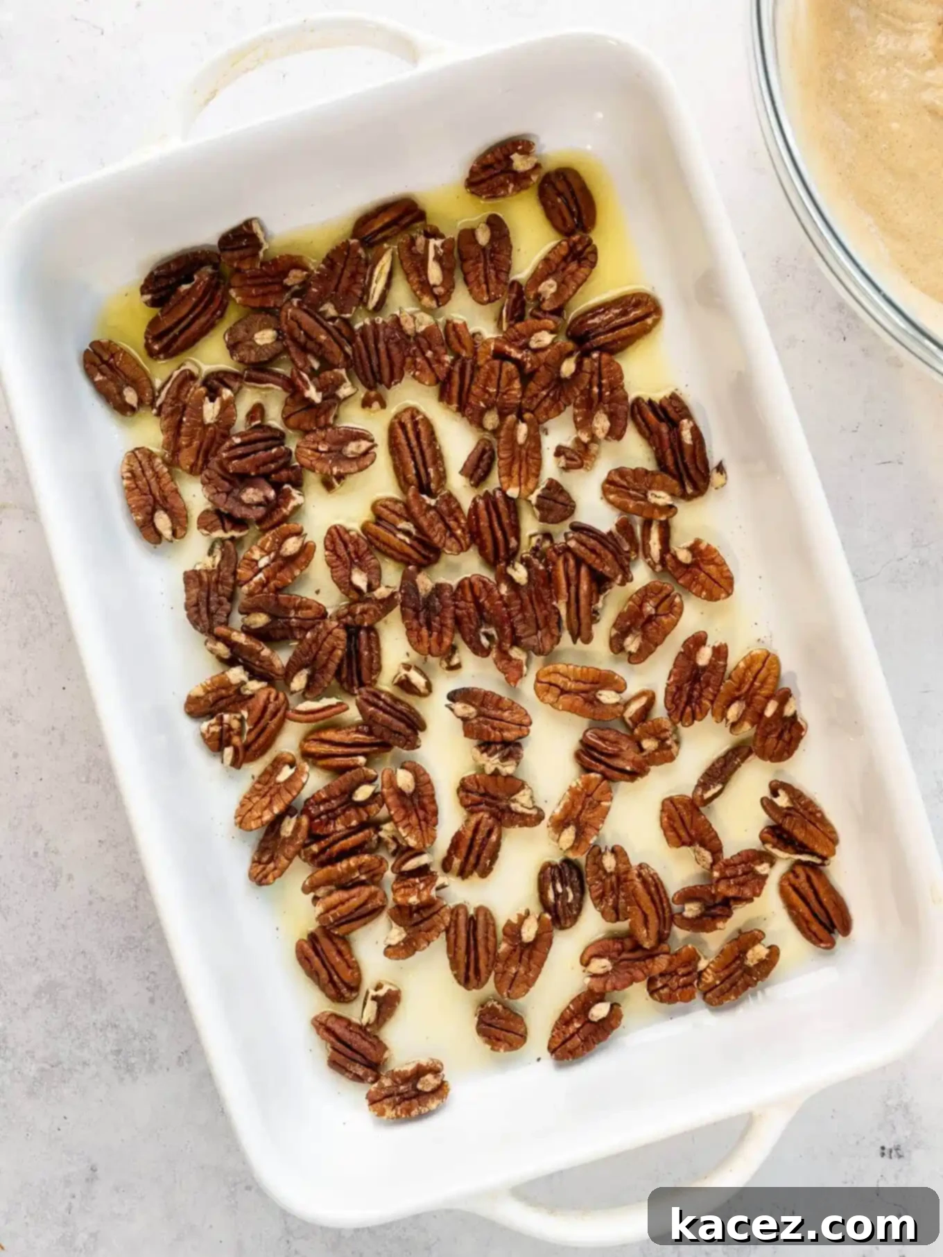 Pecan Cobbler Delight 4 An overhead view of melted butter and pecans beautifully combined in a baking dish, the first step in layering the cobbler.