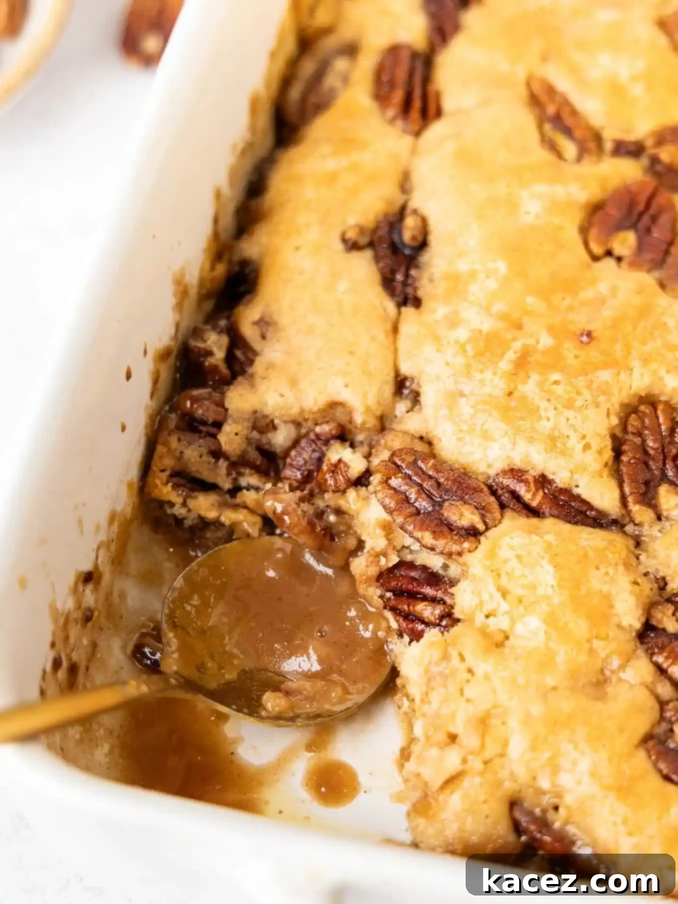 Pecan Cobbler Delight 8 A close-up view of the delectable pecan pie cobbler, with a serving already scooped out to reveal the rich filling and tempting texture.