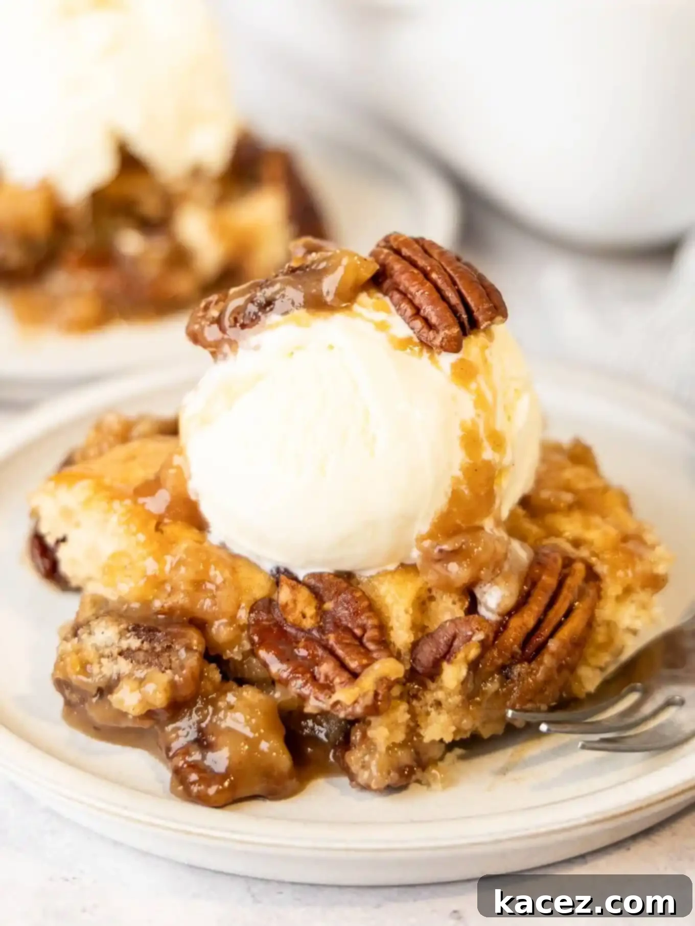 Pecan Cobbler Delight 9 A tempting serving of pecan pie cobbler crowned with a generous scoop of creamy vanilla ice cream, the perfect pairing.