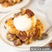 A slice of pecan pie cobbler topped with ice cream.