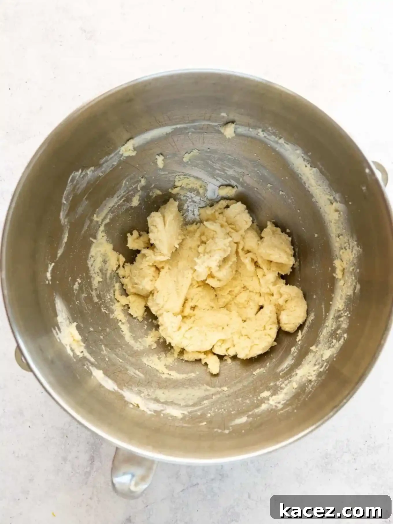 Bite-Sized Pecan Perfection 4 An overhead shot of the cream cheese crust dough in a pristine white mixing bowl, ready to be portioned.